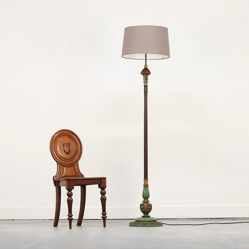 Eine einzigartige Stehlampe aus Holz, die mit türkisfarbener Farbe lackiert ist. Die alte Farbe ist sichtbar abgenutzt und verwittert, was ihr ein unverwechselbares Aussehen verleiht. Ein schönes Detail sind die geschnitzten Engelsköpfe unterhalb