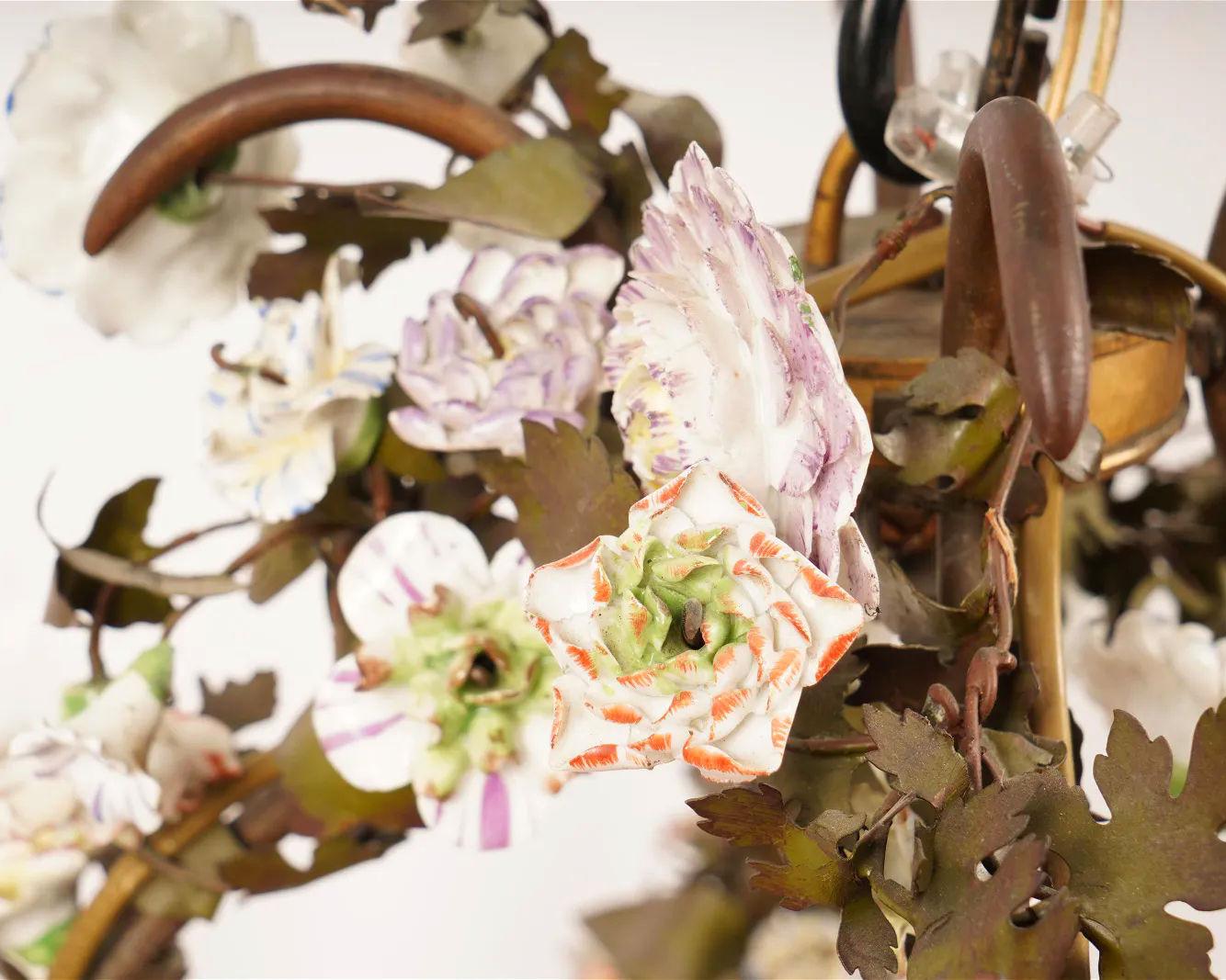 Our very large English chandelier in the form flowering vines features a porcelain jardiniere at center and eight electrified candle arms, and supplemental small bayonet style sockets (English B22 standard) on the tops of each arm. One of the finest