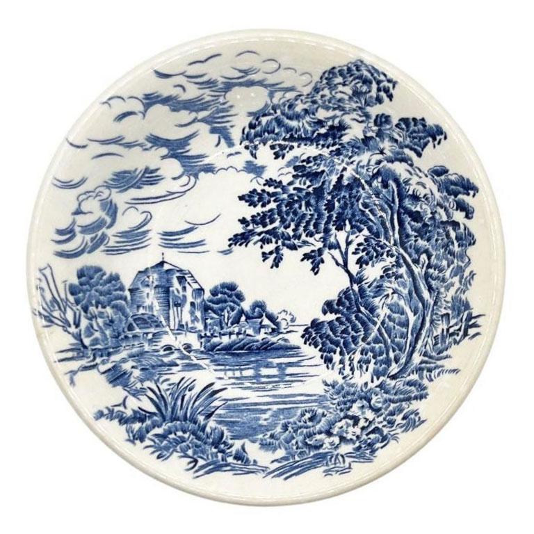 An early flow blue ceramic trinket dish or catchall by Enoch Wedgwood (Tunstall). This dish is created from a sturdy creamy white ceramic. It is decorated on the bowl's interior with a countryside scene in blue. The scene shows a manor off in the