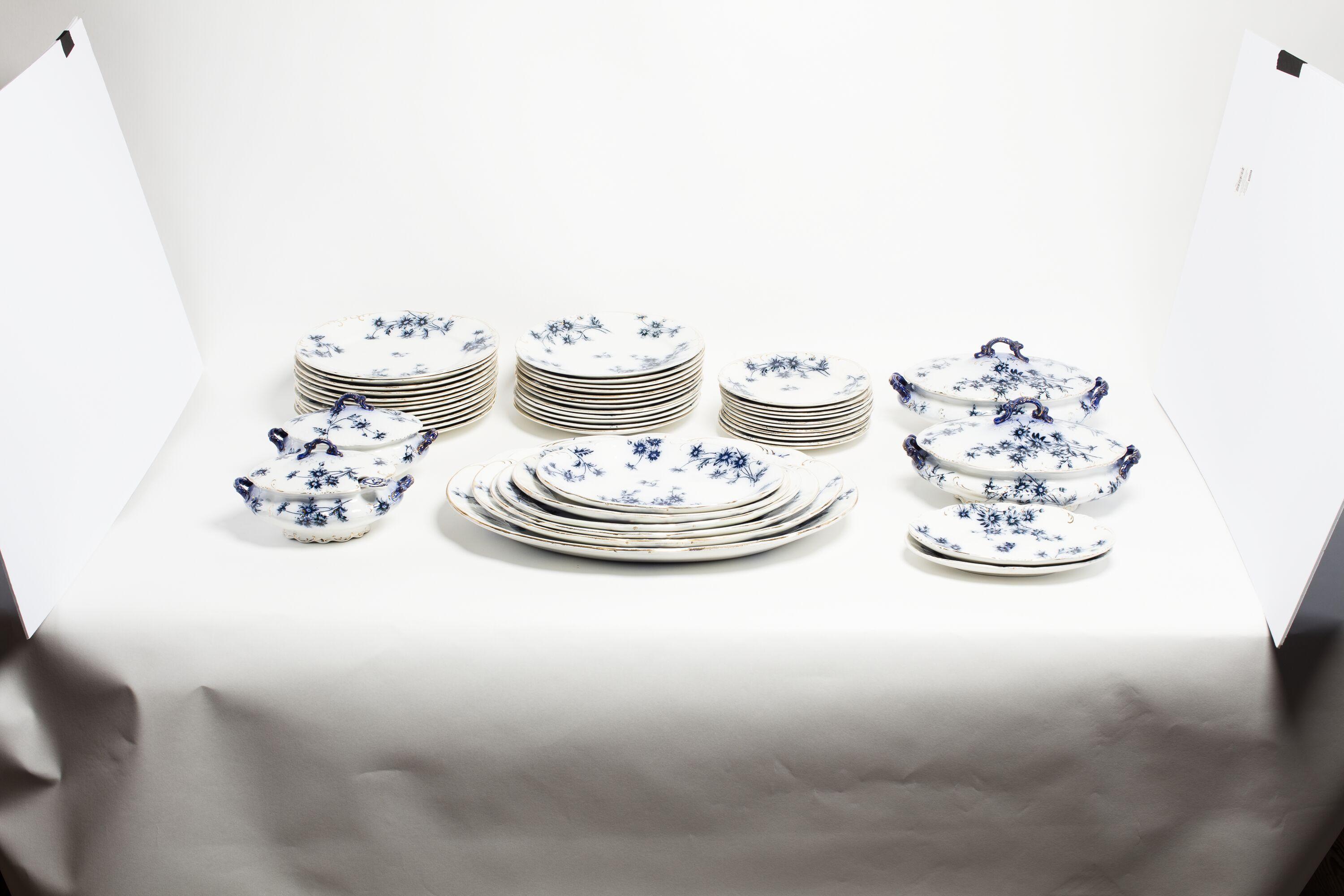 Antique flow blue English dinnerware set, ca 1860. Wear consistent with age and use. Minor chips. Set of 12 dinner plates 10.5