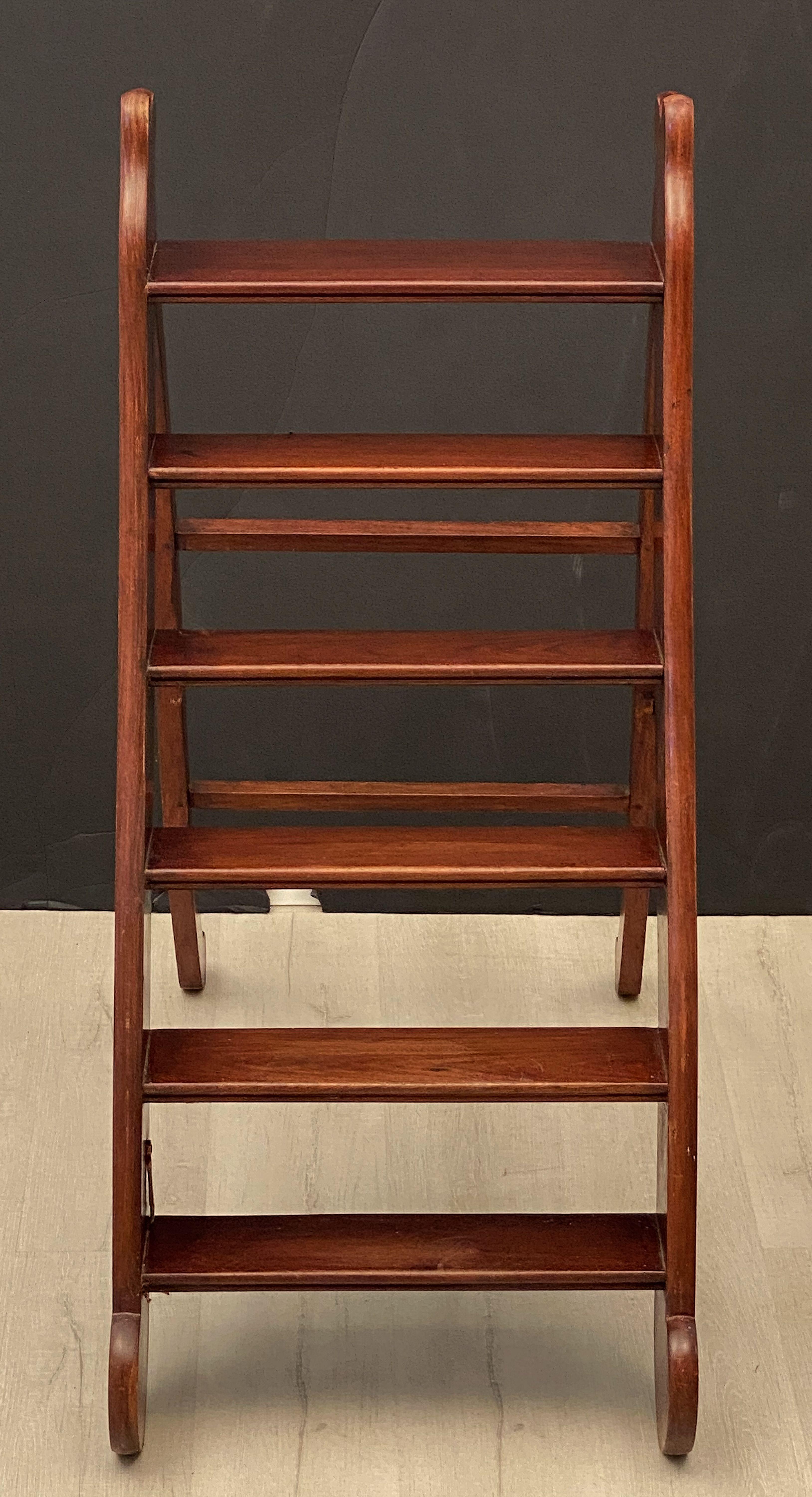 A fine period English folding library step ladder (or library steps) of mahogany with brass hardware and hook (for closed or stowaway position) from the Edwardian Era.

Dimensions when opened:

H 43 inches
W 19 3/4 inches
D 39