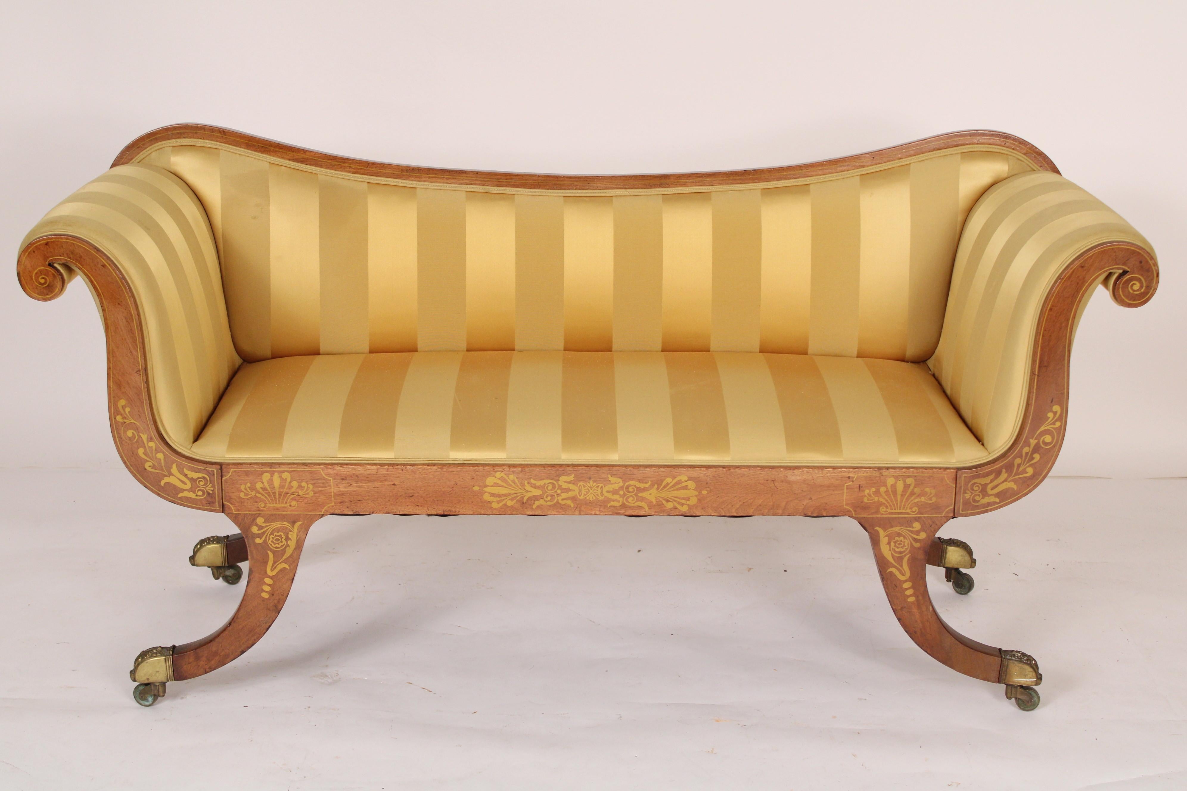 English regency painted mahogany settee with striped silk upholstery, brass feet and casters, 19th century.