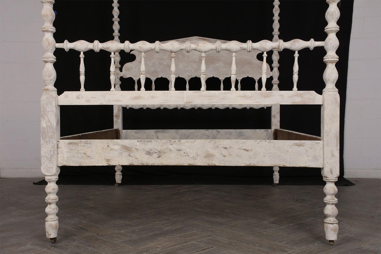 This late 19th century painted English tester bed with distressed finish features four carved posters and designed headboard. The canopy has been reupholstered in an off-white color linen fabric. This bed is sturdy, elegant, and ready to be used in