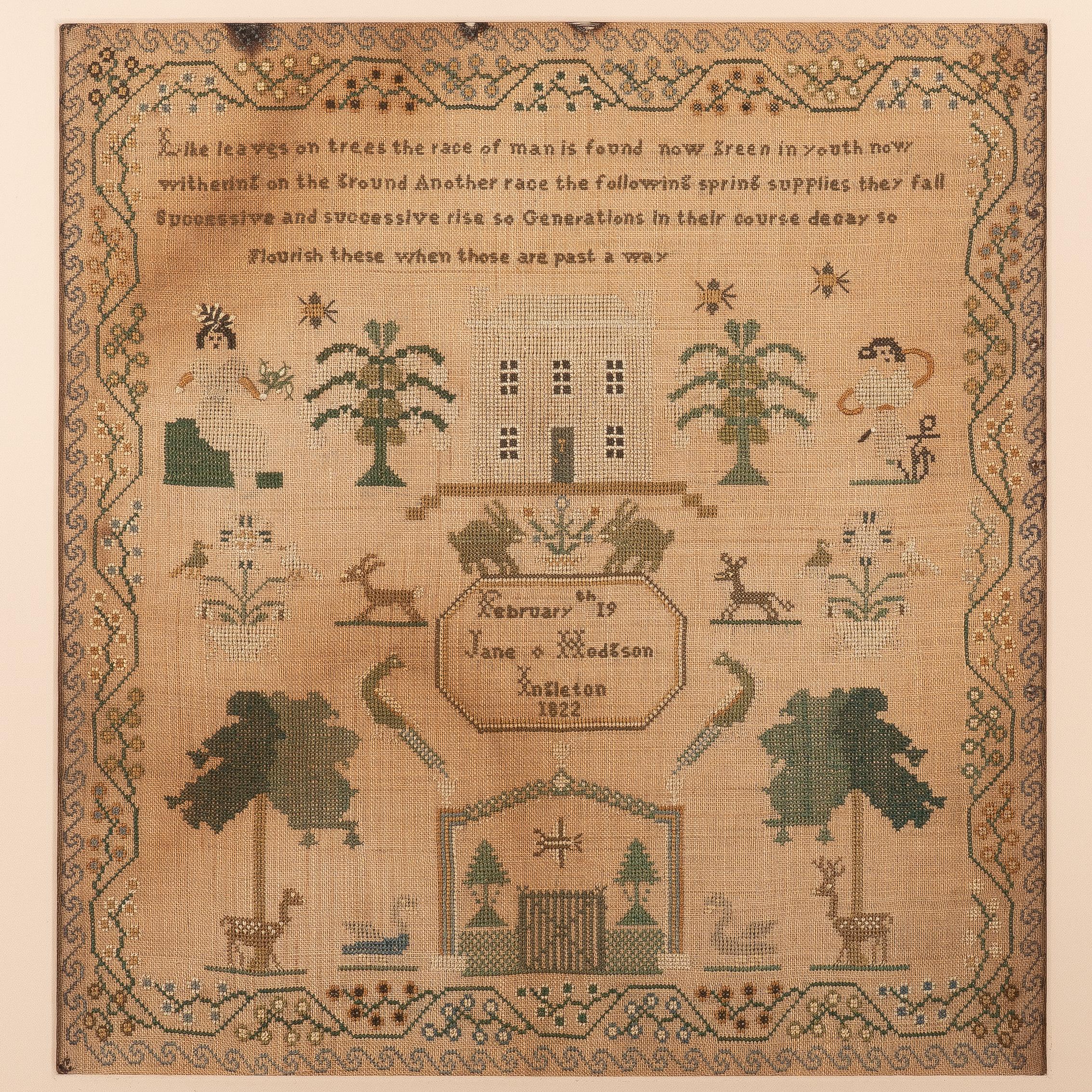 Needlework sampler of silk floss on linen in green, brown, and white on a natural linen ground. The work includes the lines: “Like leaves on the trees the race of man is found now green in youth now withering on the ground. Another race following