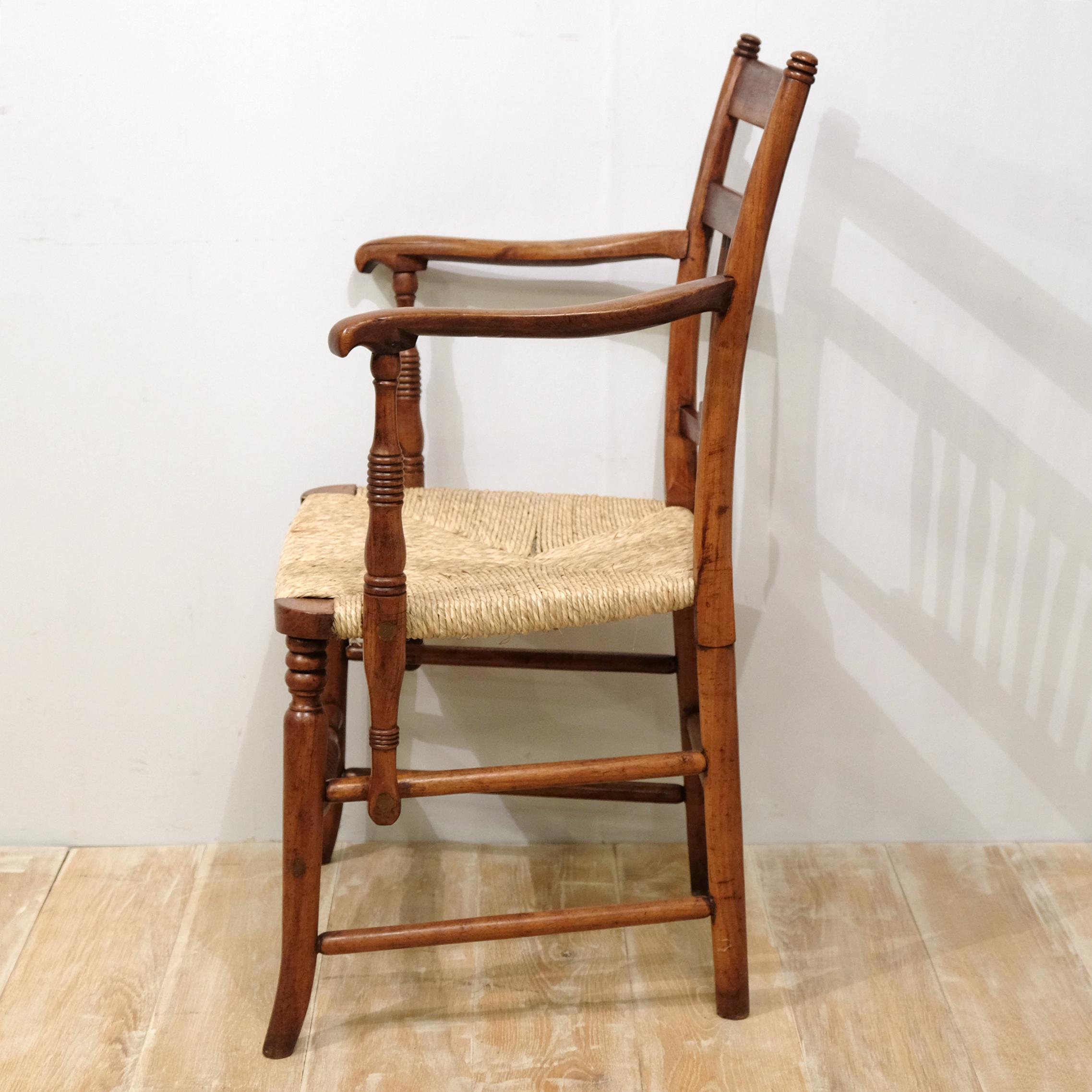 An exceptionally high quality chair in fruitwood with rush seat (recently re-rushed). Attributed to Sussex with its similarities in design to the chairs of Morris & Co but with distinct influences from East Anglia and the United States. Sculpturally