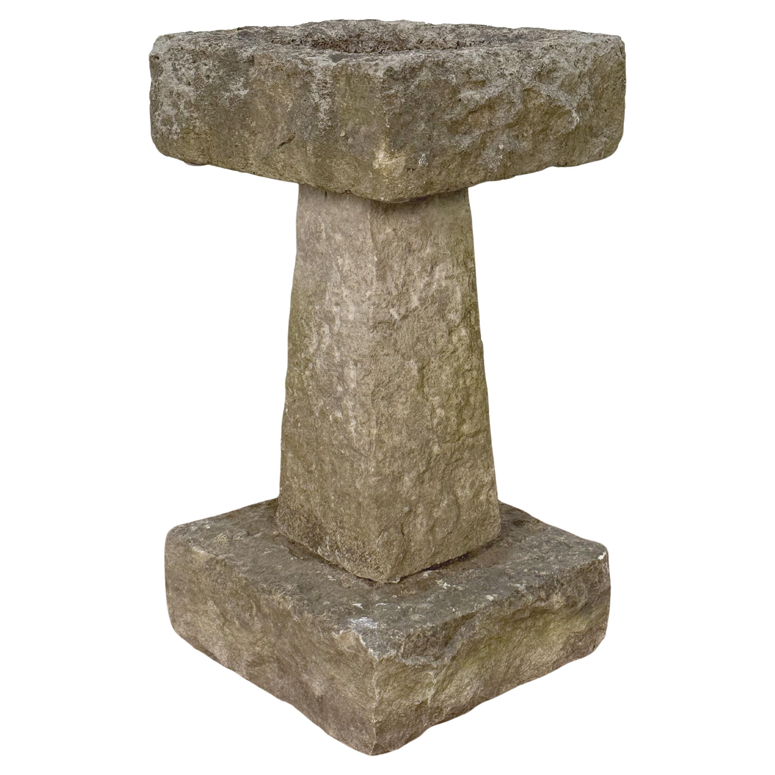 A fine English garden bird bath of cut and chiseled Purbeck stone, from the late 19th century, featuring a square top with round recessed bath area in the center, set upon a four-sided tapering pedestal with square plinth base. 

Purbeck stone