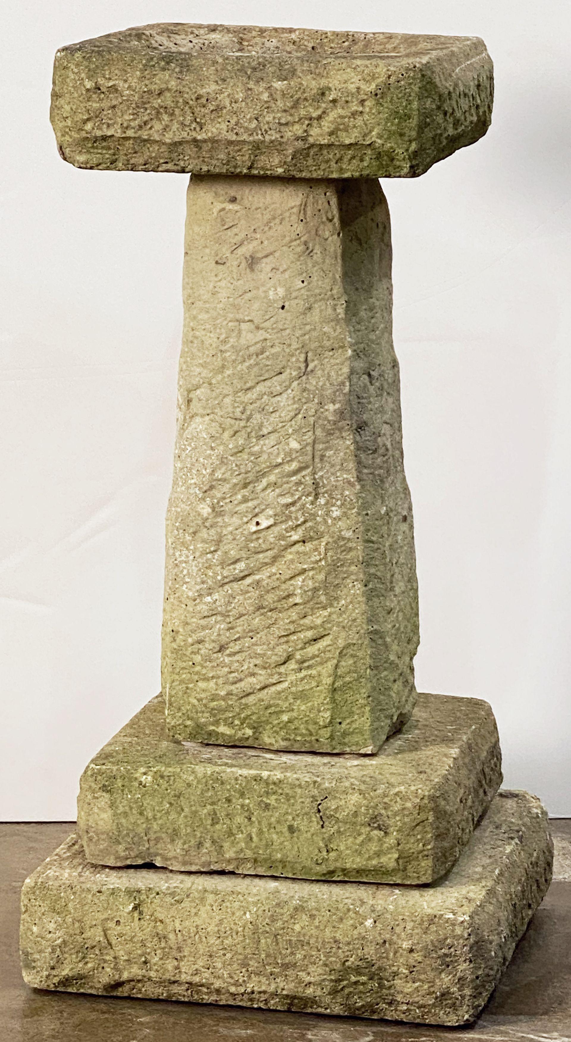 A fine English garden bird bath of cut stone, featuring a square top with round recessed bath area in the center, set upon a four-sided pedestal with graduated square plinth base.

Dimensions: H 28 1/2 inches x Base W 14 1/2 inches x Base D 14 1/2