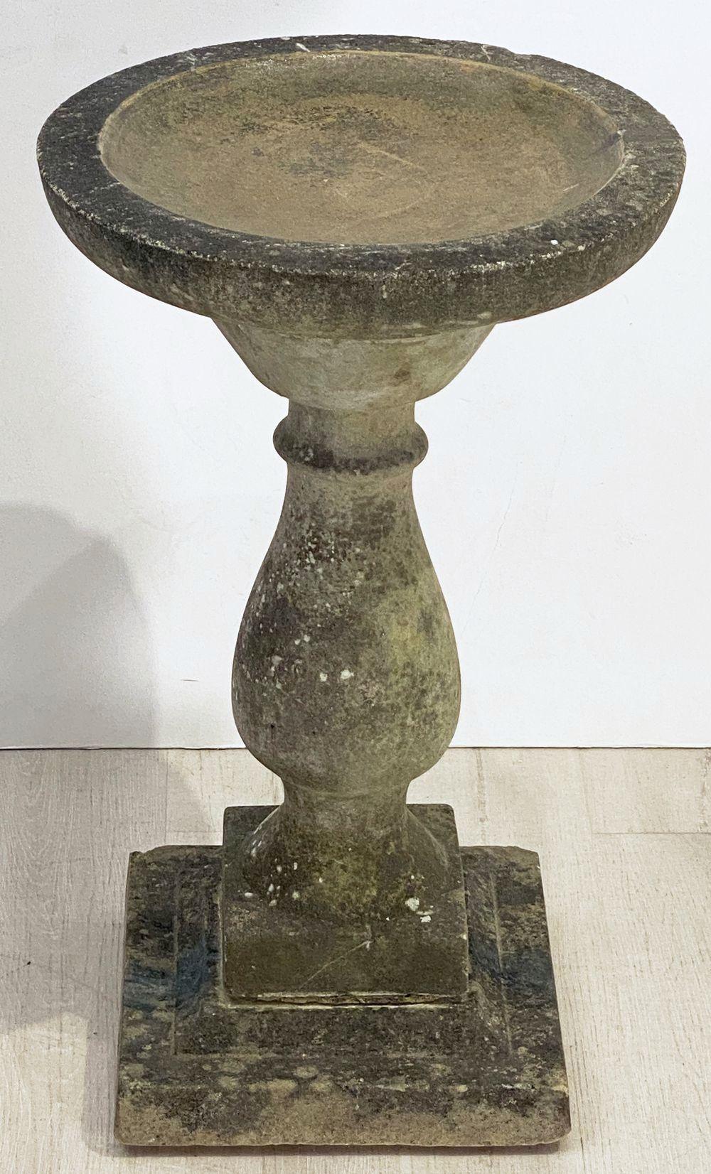 A handsome English bird bath (or birdbath) of composition stone, featuring a 17 1/2 inch diameter basin top (circular) set upon a Classical baluster pedestal column and raised square plinth base.

Basin depth is approximately 1 1/4 inches.

Perfect