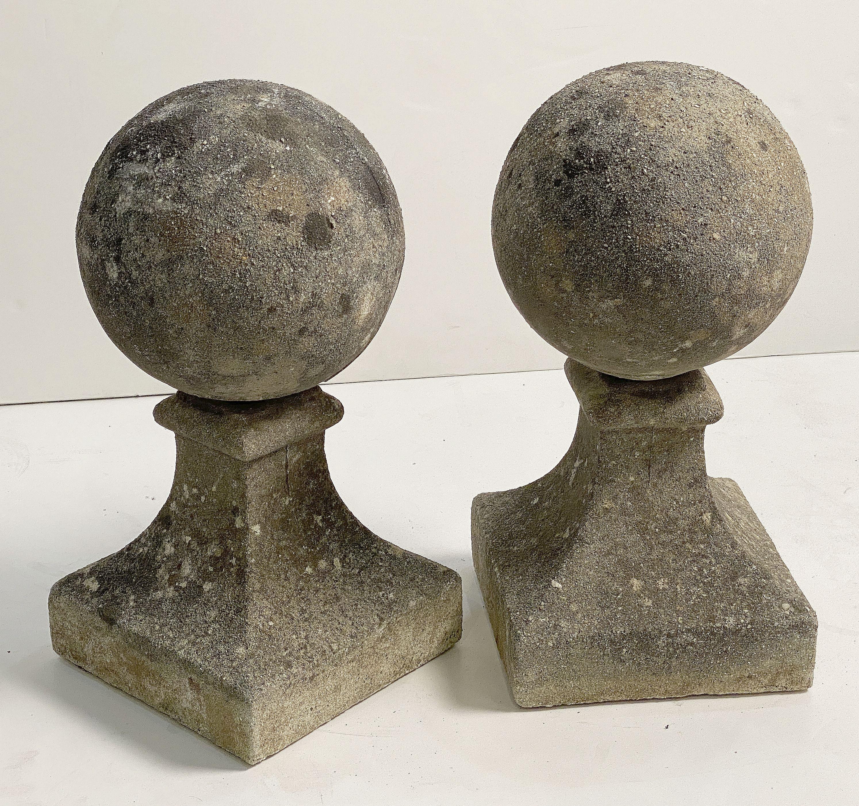 A fine pair of English coping balls of composition stone, each ball set upon a square plinth base.

Dimensions are H 19 inches x W 9 1/2 inches x D 9 inches

Perfect for use as an indoor or outdoor garden, garden room, or patio feature!

Two