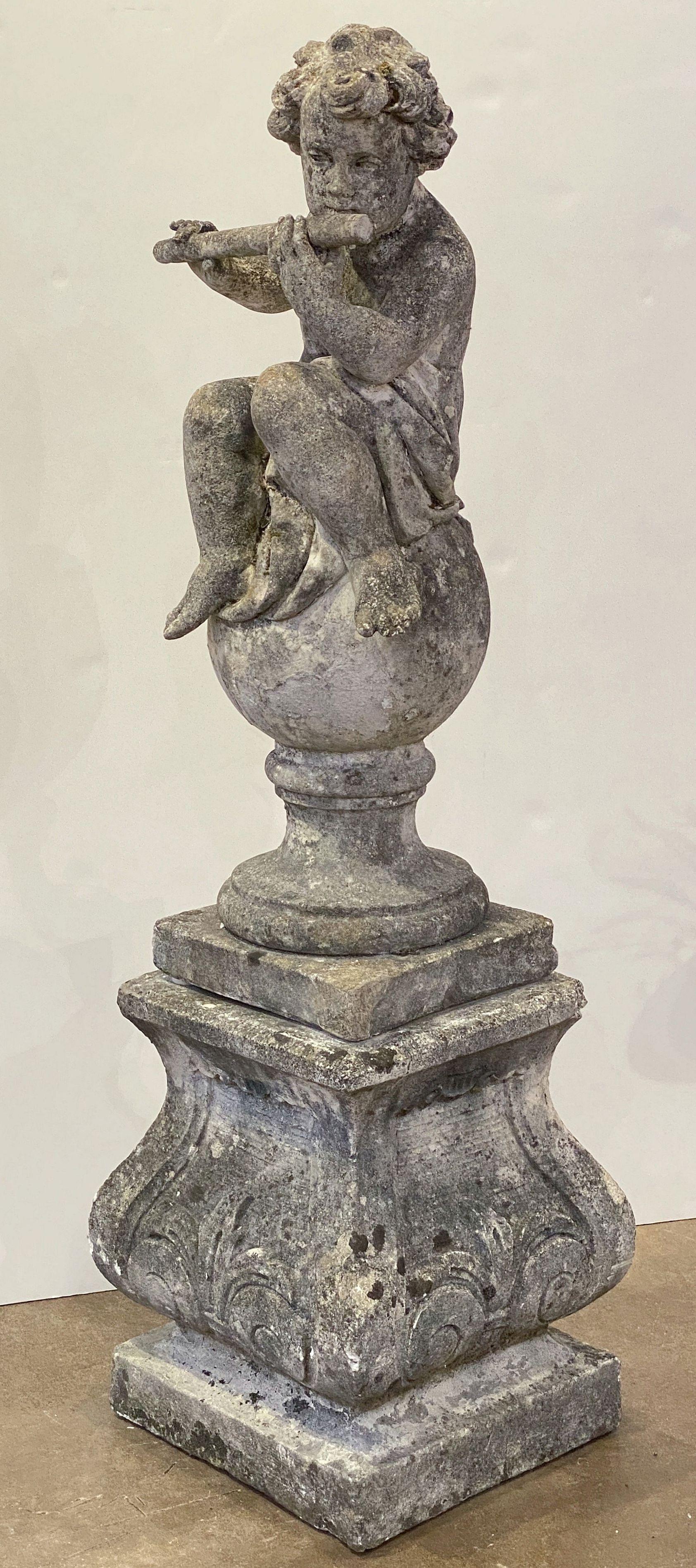 A fine English garden statue or ornamental figure of composition stone, featuring a cherub or child putti in the Classical style, posed in a sitting position, playing a flute, on a ball and plinth base.

Excellent in the round detail.

Perfect for a