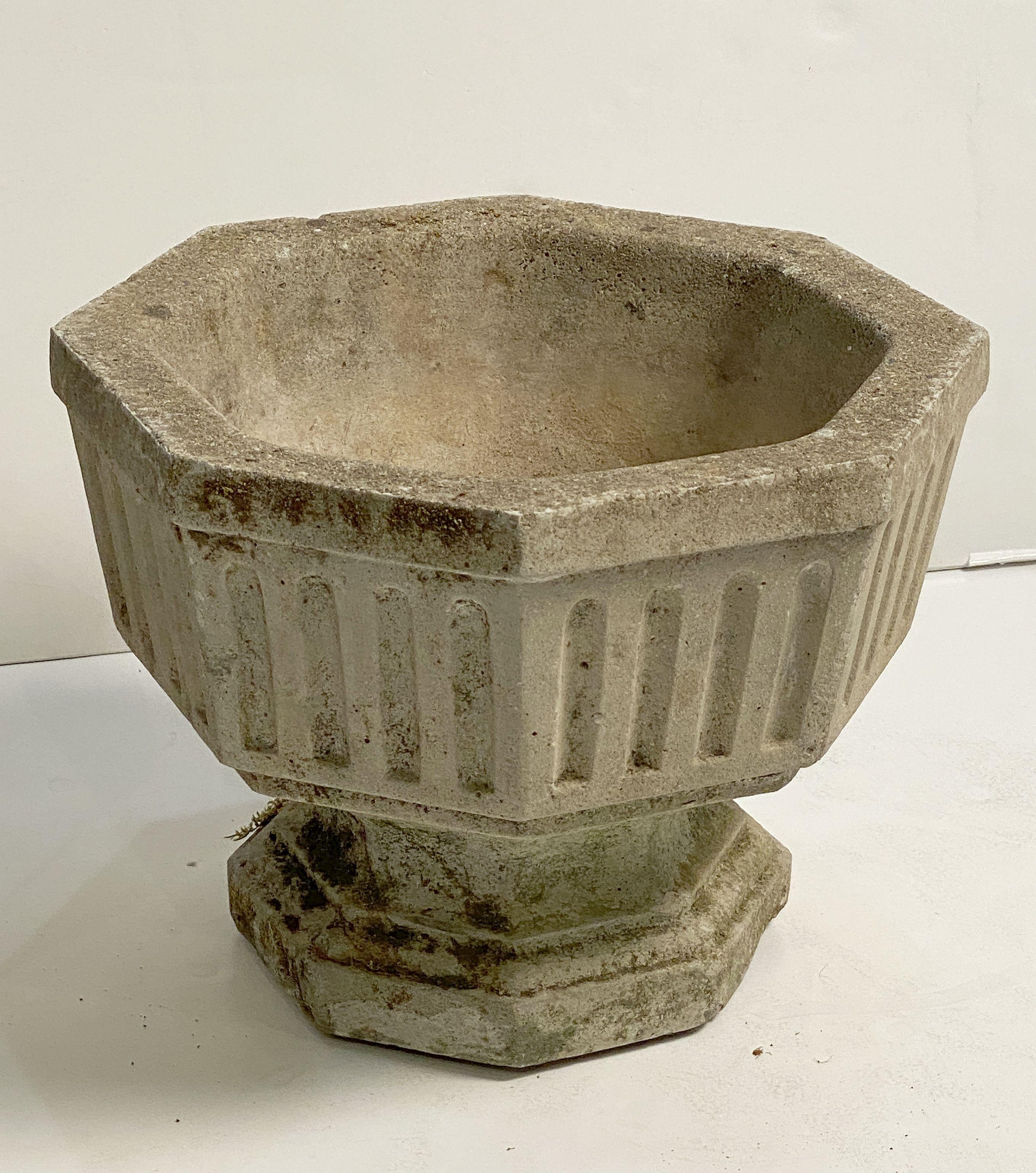 A fine pair of English octagonal garden urns or planter pots of composition stone - each planter featuring a relief design around the circumference over a raised eight-sided base.

Two available, individually priced, $1395 each planter