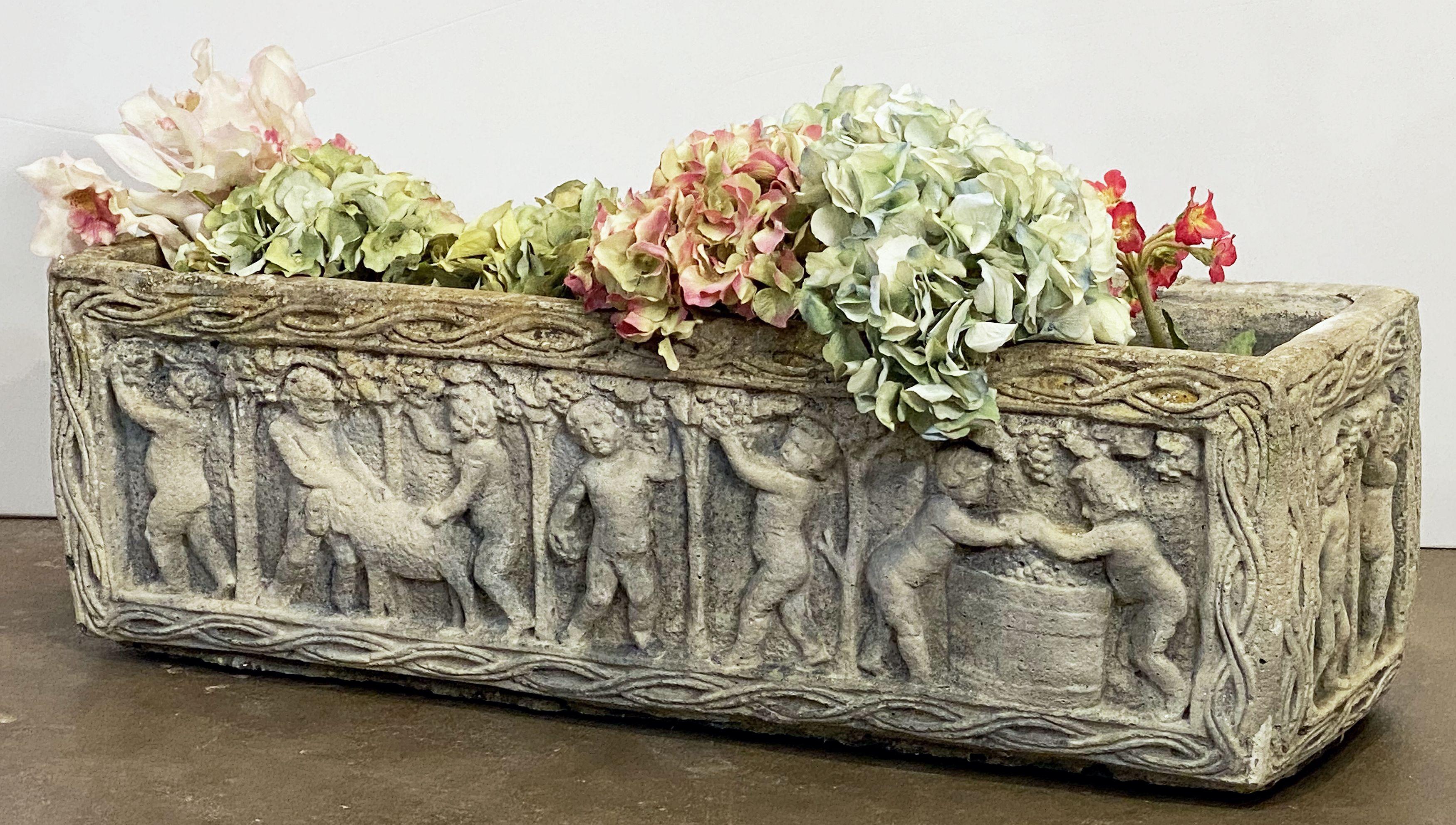 A fine English rectangular garden trough of planter with an ornamental Classical relief of cherubs on all four sides.