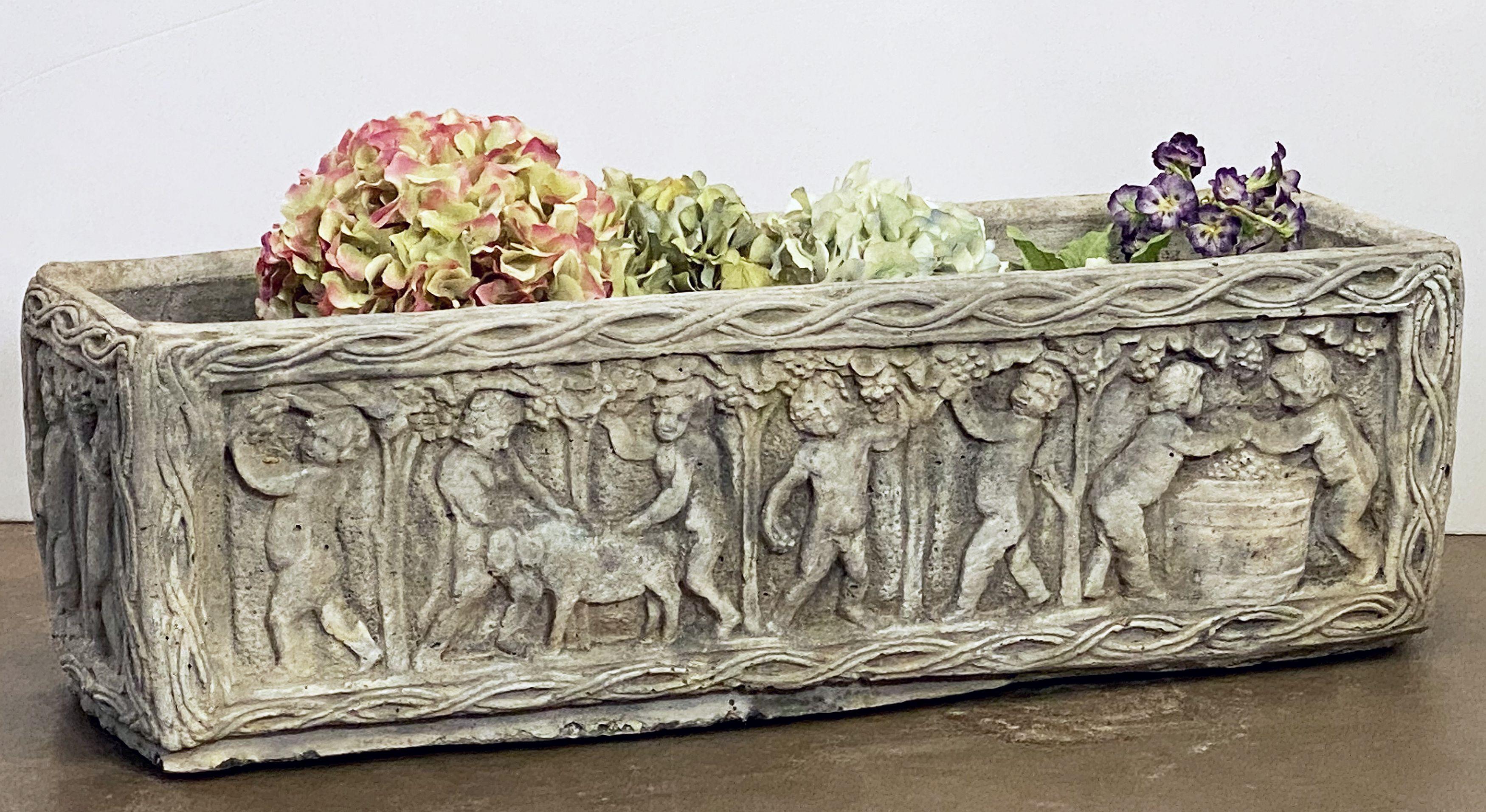 A fine English rectangular garden trough of planter with an ornamental Classical relief of cherubs on all four sides.