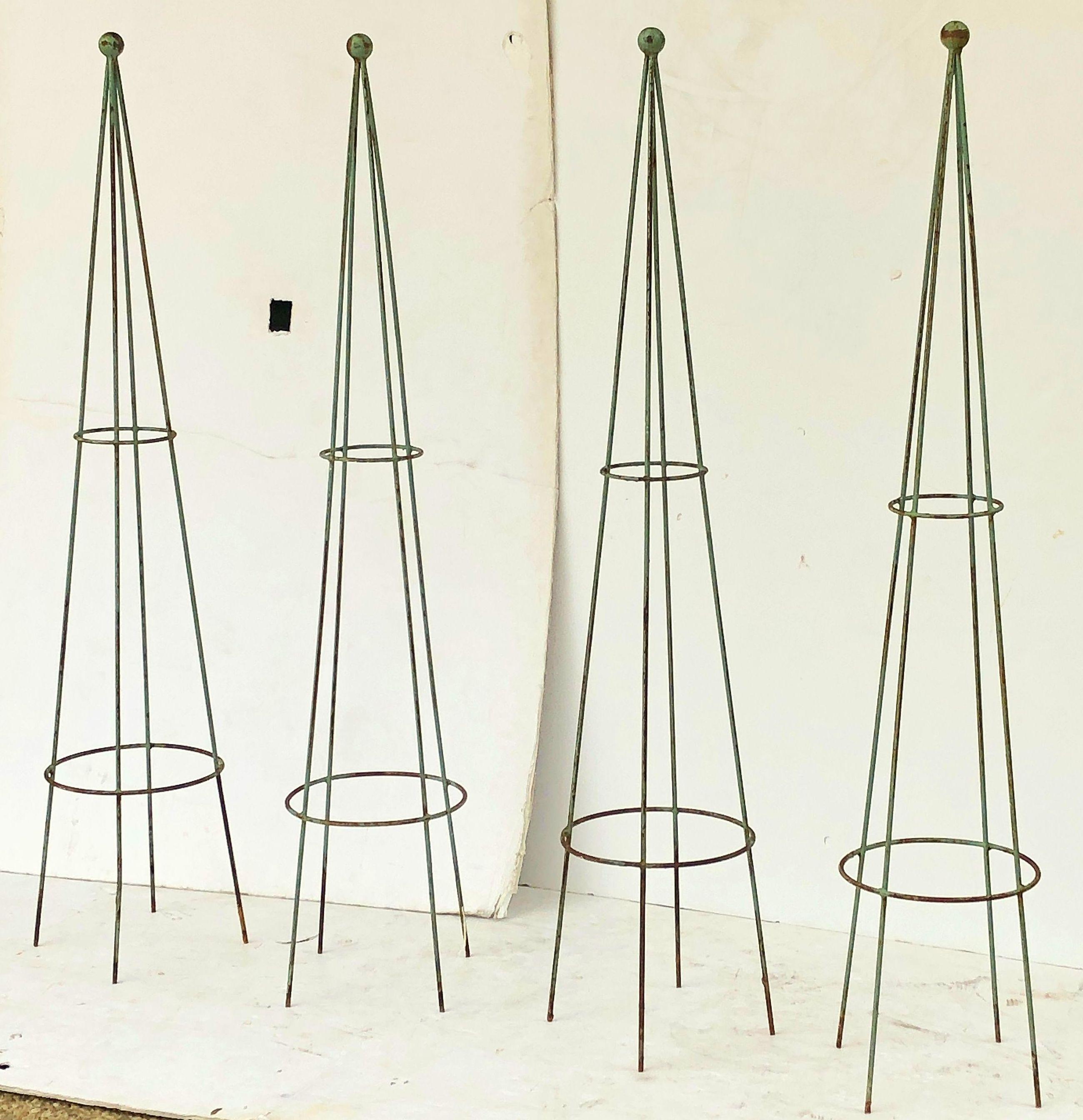 A set of English garden trellis obelisks of painted iron, each featuring a round finial top and four rods.

Measures: Height 60 1/2 inches x diameter 13 1/2 inches

Four available, individually priced, $895 each obelisk.