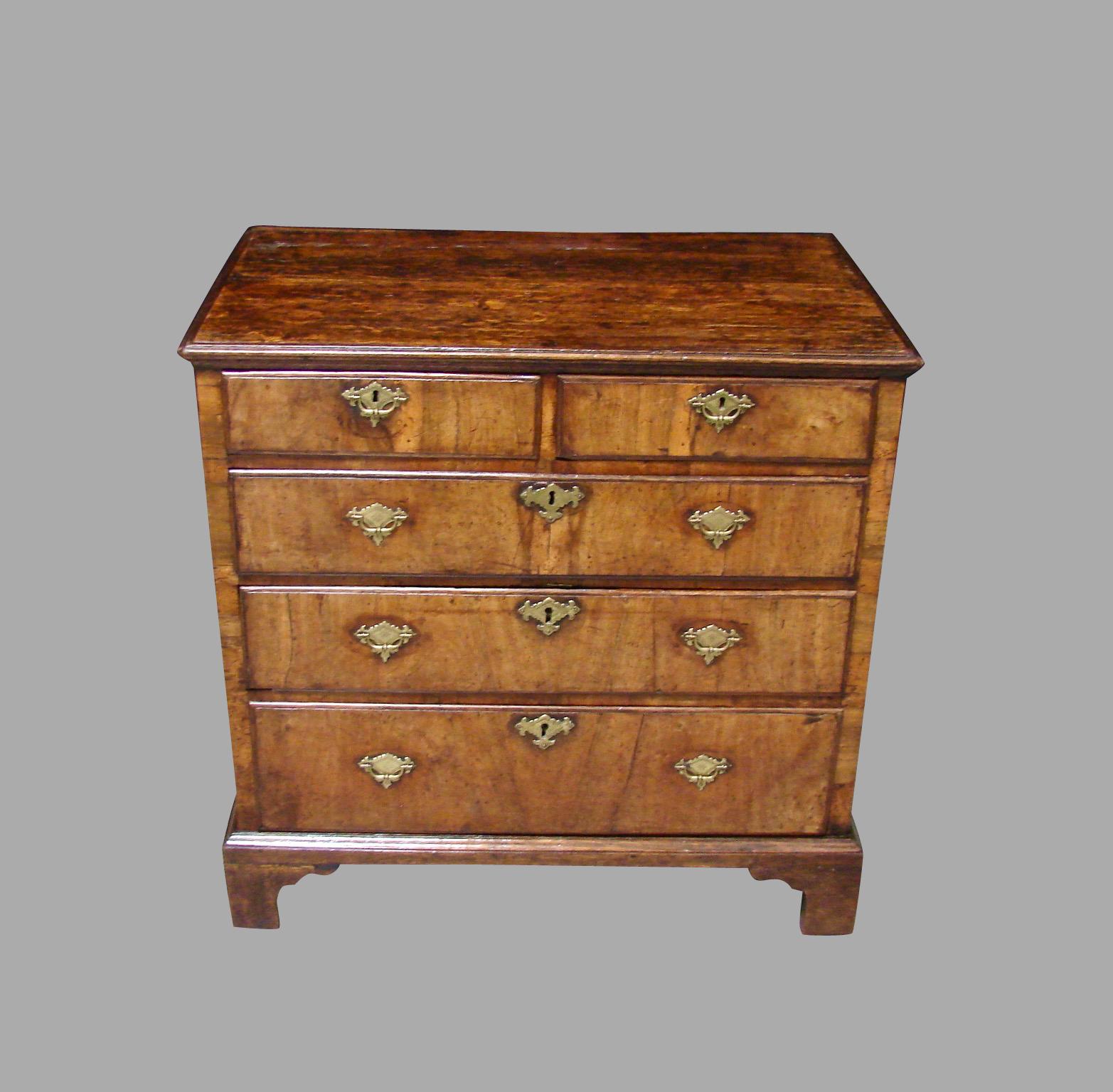 An English provincial oak and walnut 5-drawer chest, the top and paneled sides made of solid oak, the drawer fronts veneered in lovely figured walnut, all resting on bracket feet, circa 1750.