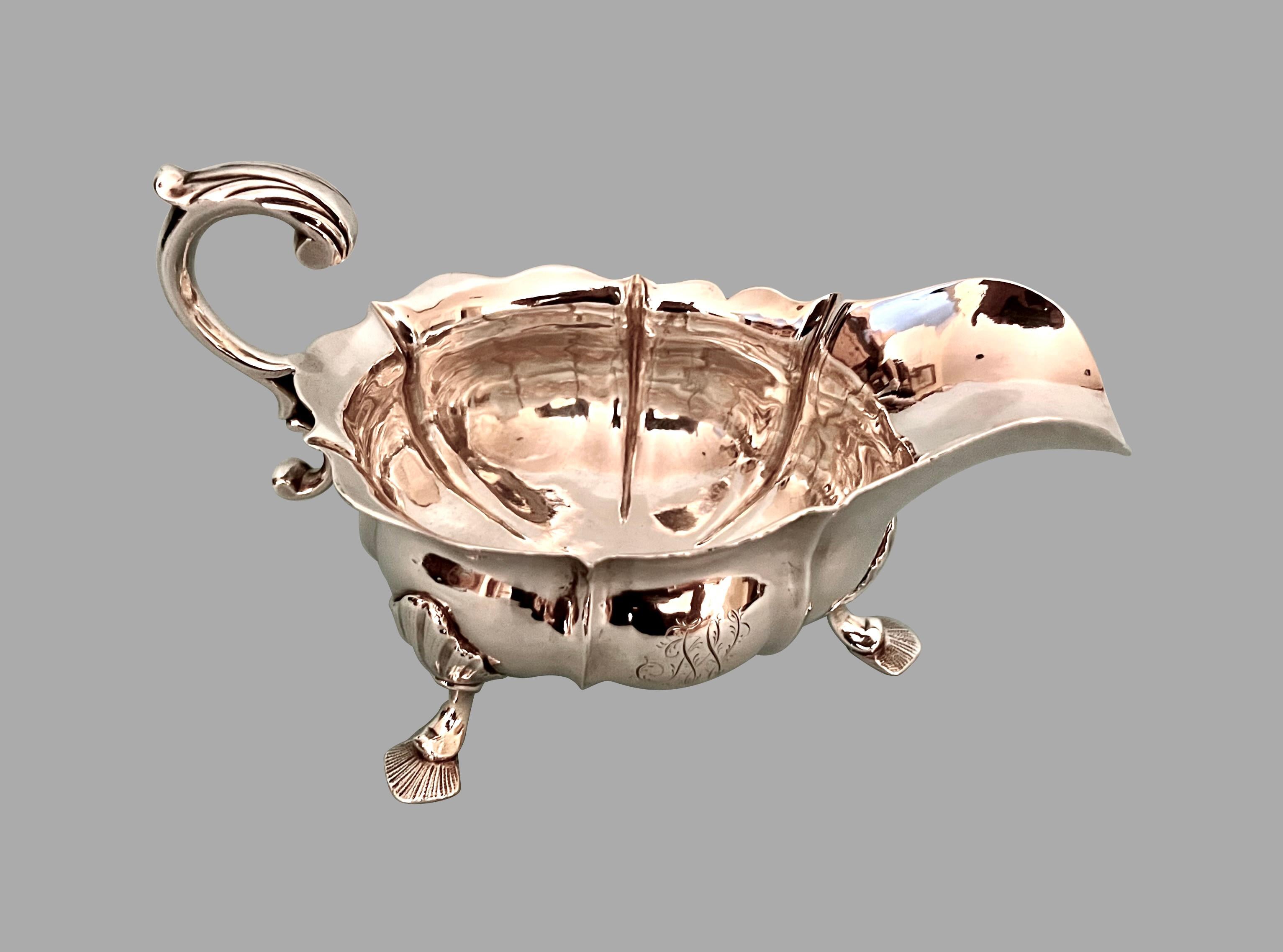 An English George II period sterling silver sauce boat of typical form, the base hallmarked JB with other hallmarks, (except the lion passant) rubbed. Monogrammed on one side. An elegant heavy gauge sauce boat. Weight 320 grams.