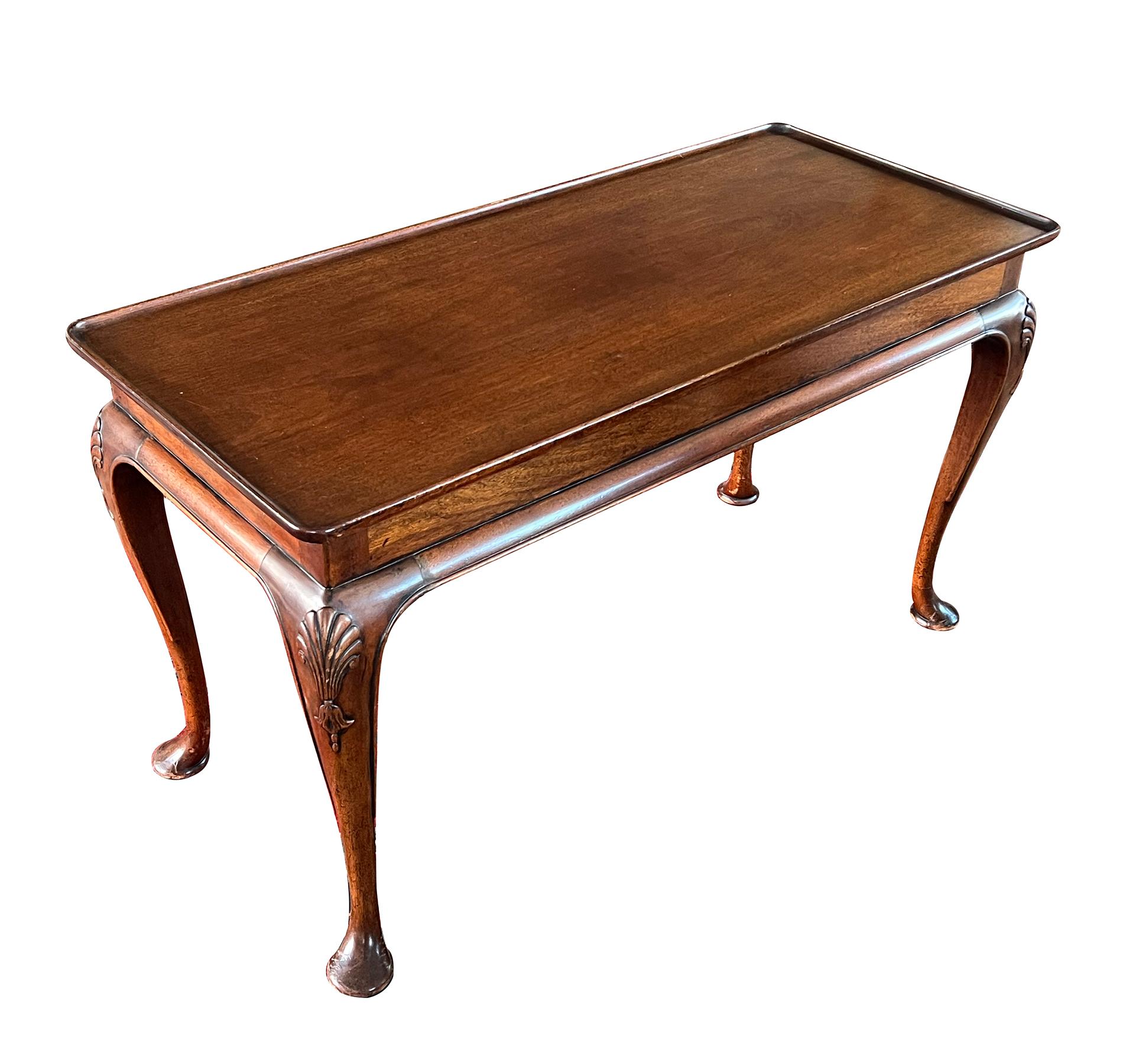 the rectangular dish top with raised molded edge above a plain frieze apron above a rolled perimeter molding; raised on elegantly-shaped cabriole supports with shell carved knees all ending in pad feet