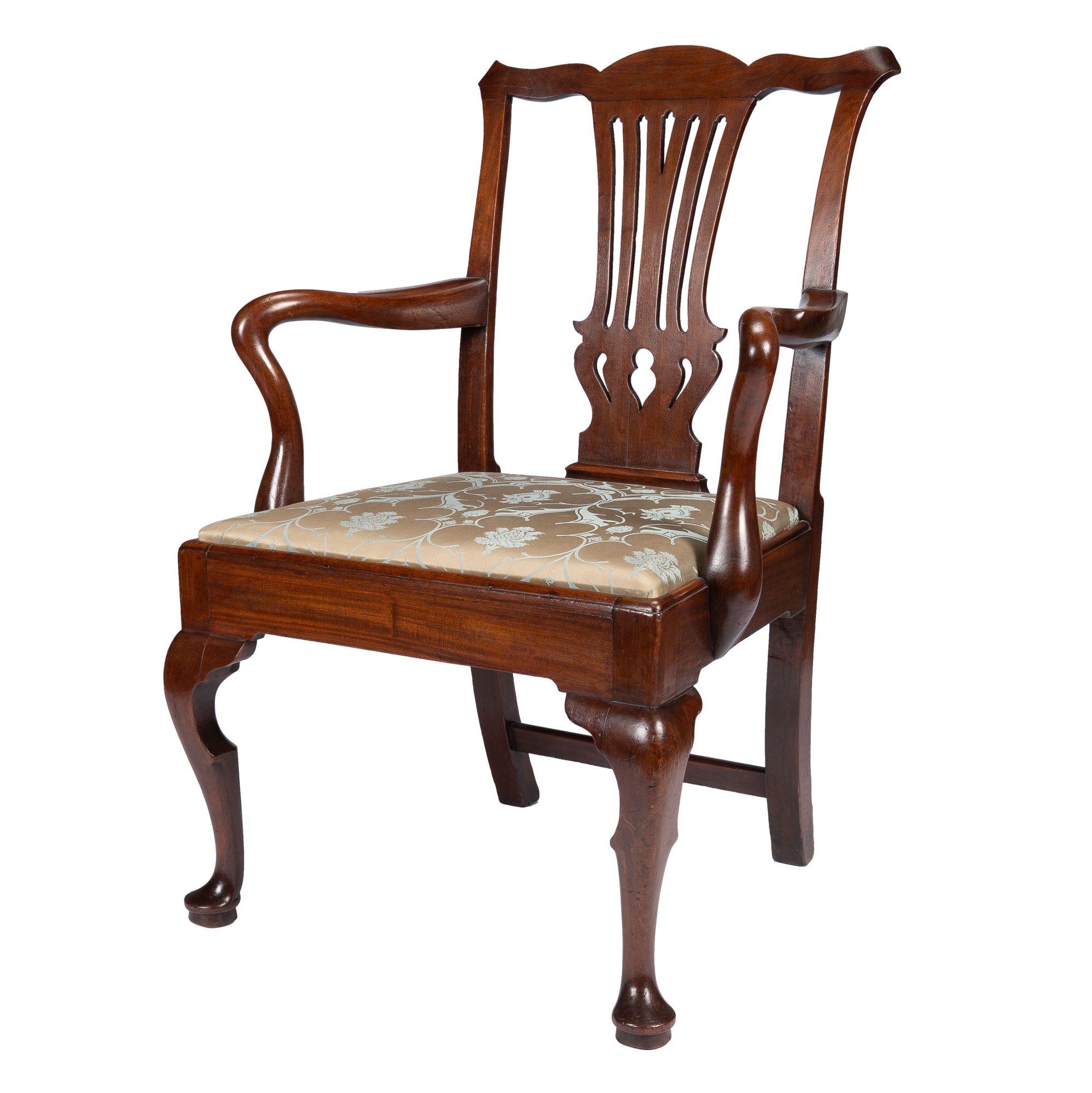 George II shepherd's crook armchair in old-growth mahogany. The pierced back splat is framed between the cupid’s bow crest rail with scroll carved ears and the slip seat shoe. The front cabriole legs terminate in pad feet and the splayed rear legs