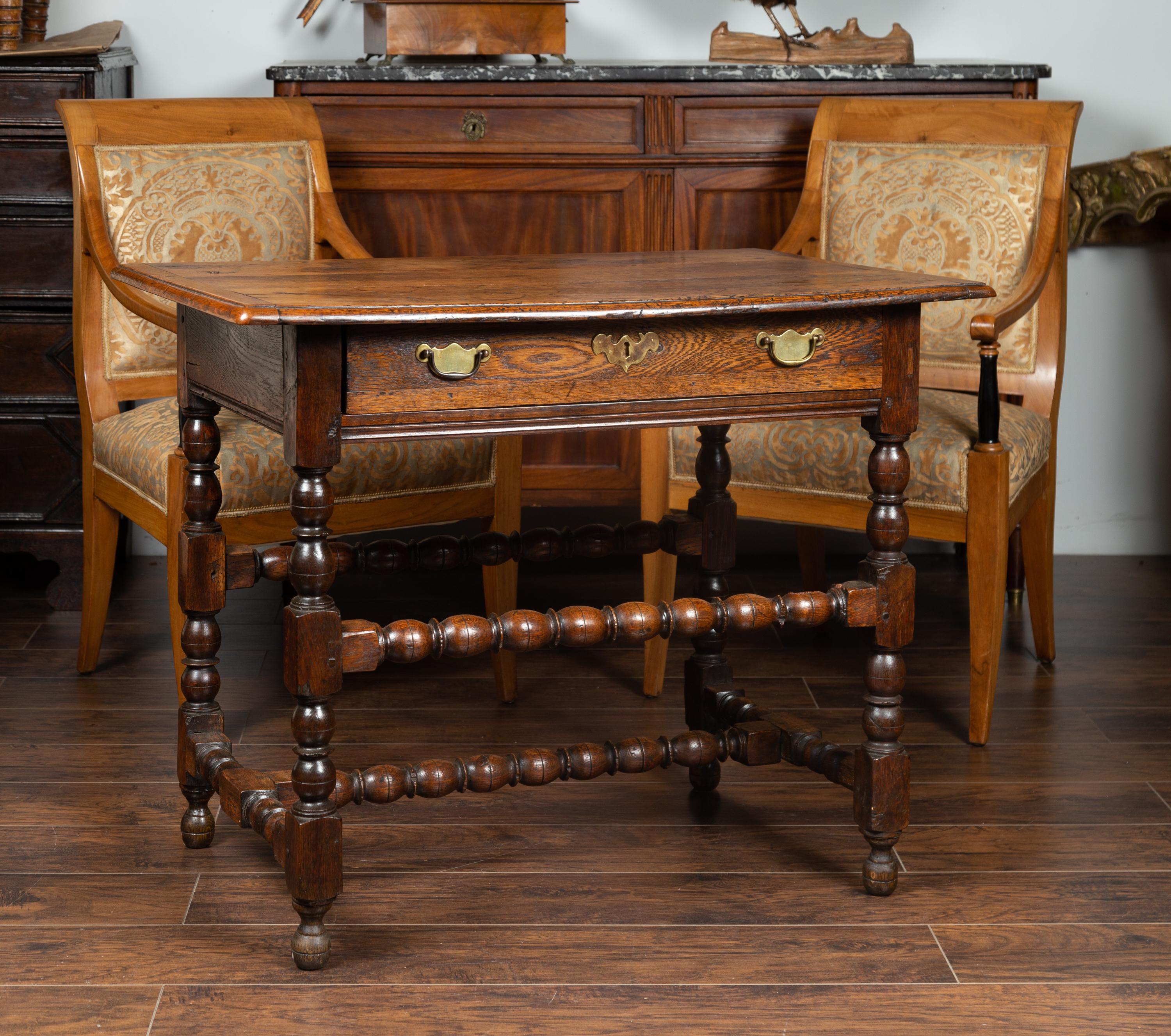 An English George III period oak side table from the early 19th century, with single drawer and bobbin stretchers. Born in England during the early years of the 19th century, this handsome side table features a rectangular top with beveled edges,