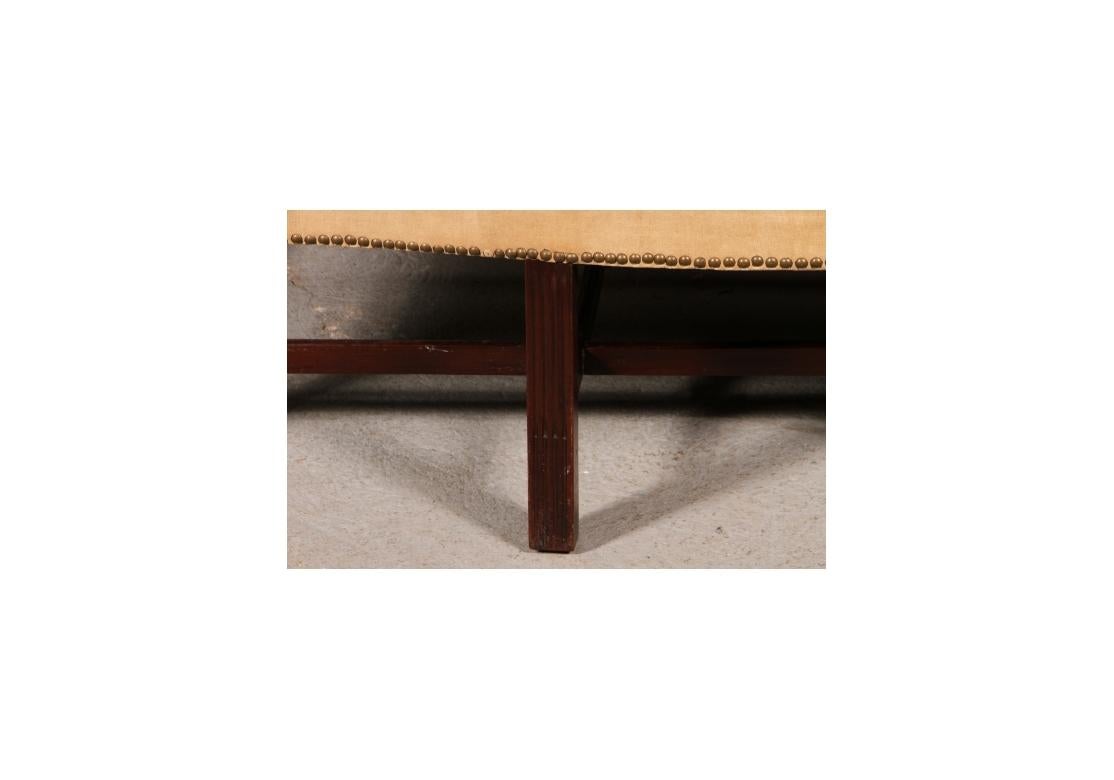 Canapé à dos de chameau à accoudoirs roulés avec décorations en laiton sur un siège de forme rectangulaire reposant sur des pieds en blocs d'acajou avec des supports en H à trois branches. 

Dimensions : 76