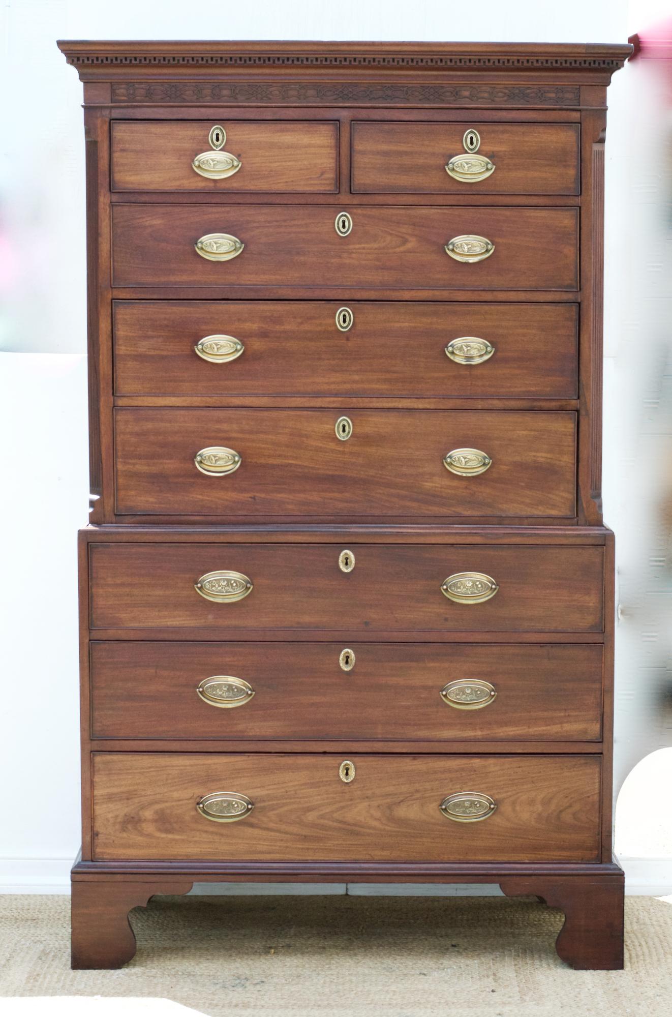 A period George III chest on chest having Greek key moulding atop the two short over three long drawers that reside above a lower dresser base having three long and gently graduating drawers. The Classic and stalwart storage dresser is in the
