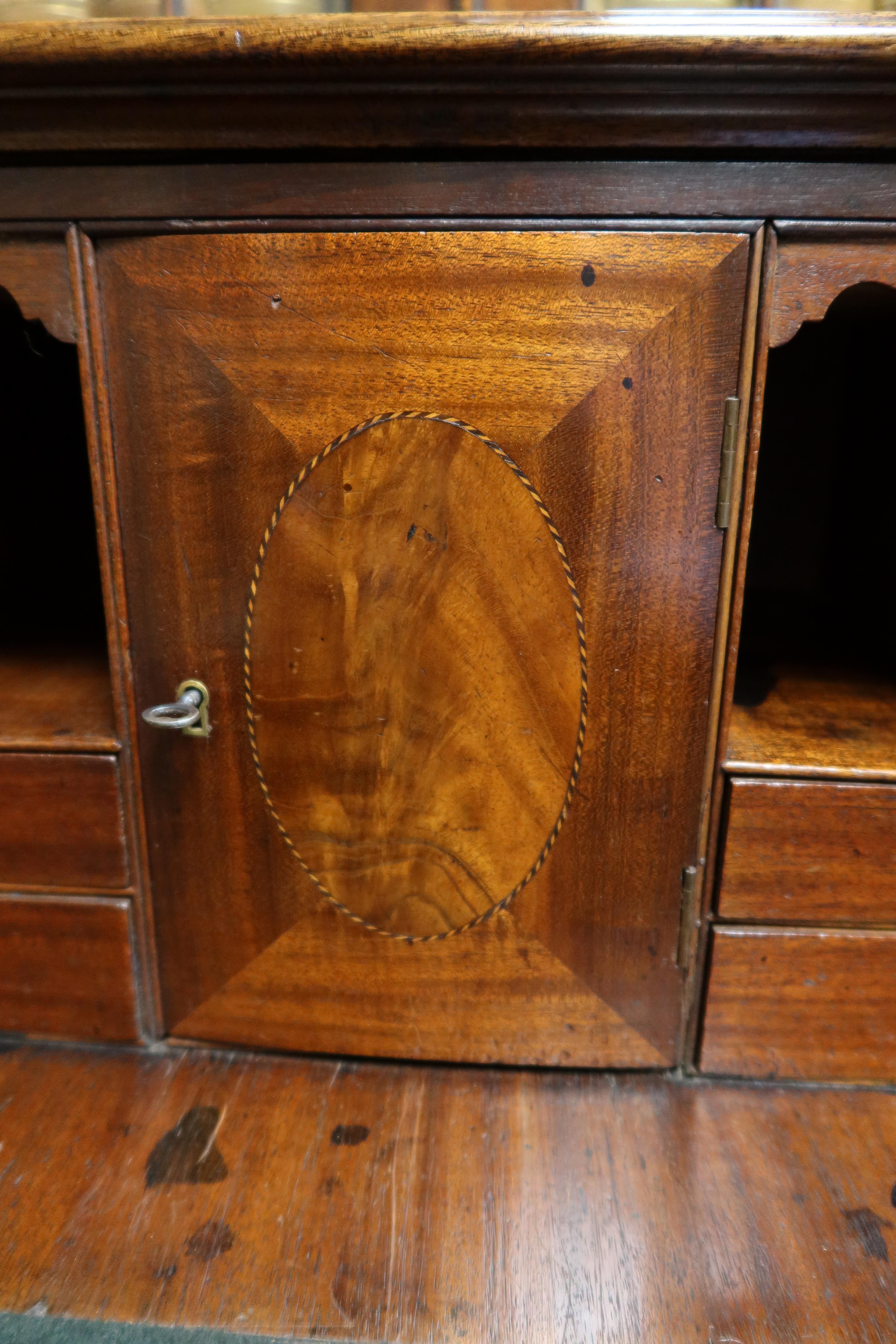A fine antique English George III mahogany Chippendale secretaire bookcase. Superb mahogany veneers and the use of decorative stringing and crossbanding enhance the classic lines. The top drawer has its original brass swan necks handles and pulls