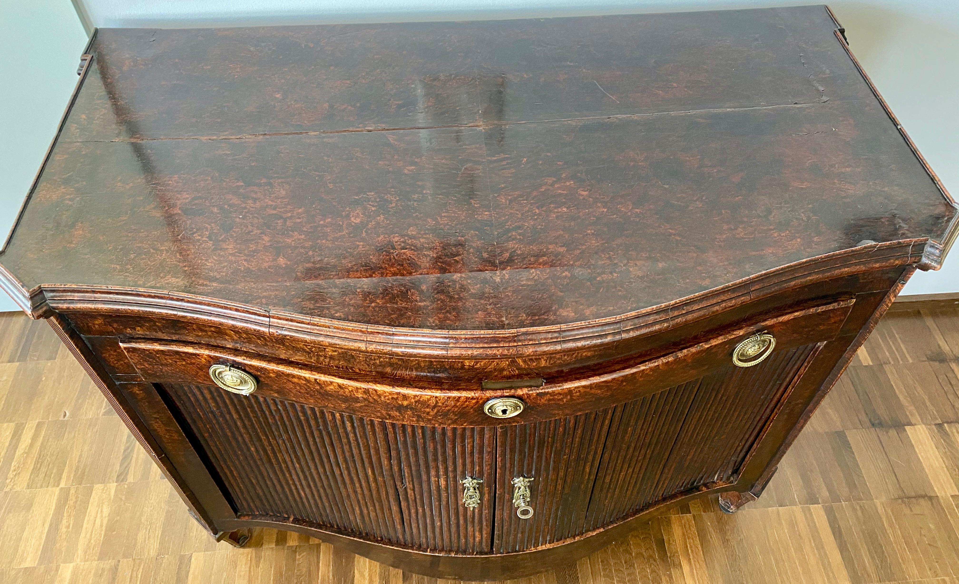 Dutch Burl Mahogany Commode/Sideboard, Late 18th Century

The mahogany commode has a serpentine design that includes a drawer and cabinet below. When you lift open the top, the commode transforms into a bespoke sideboard.
The sideboard mode extends