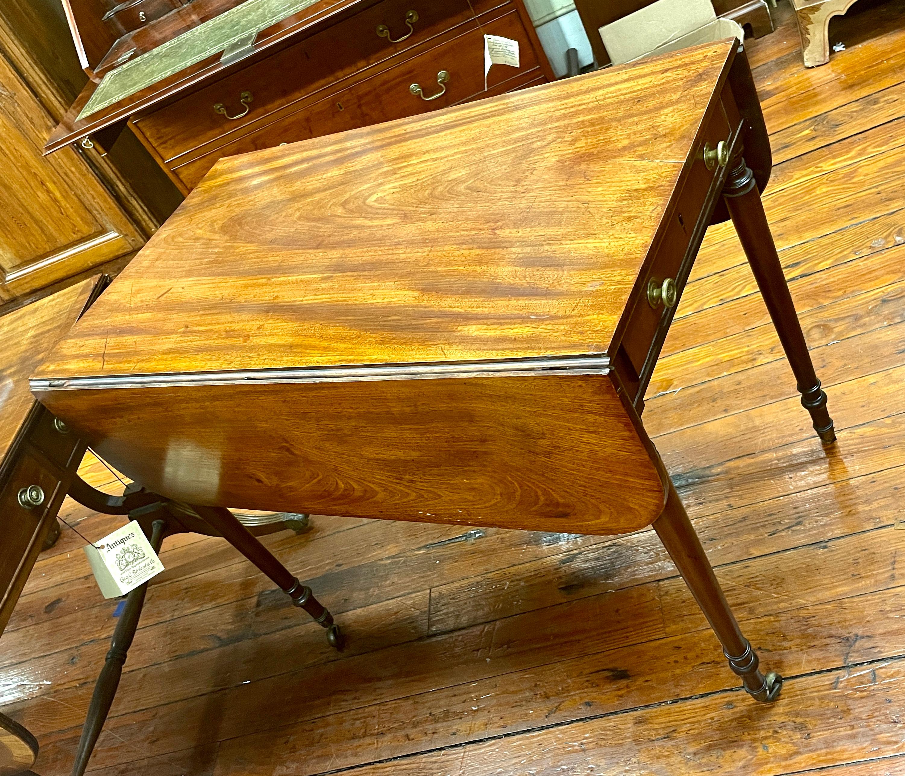 Fine quality antique English George III figured honey colored mahogany Sheraton style drop-leaf Pembroke table. The patinated honey-colour has been lovingly acquired over the past 200 years. Superb highly figured mahogany. Original brass casters.