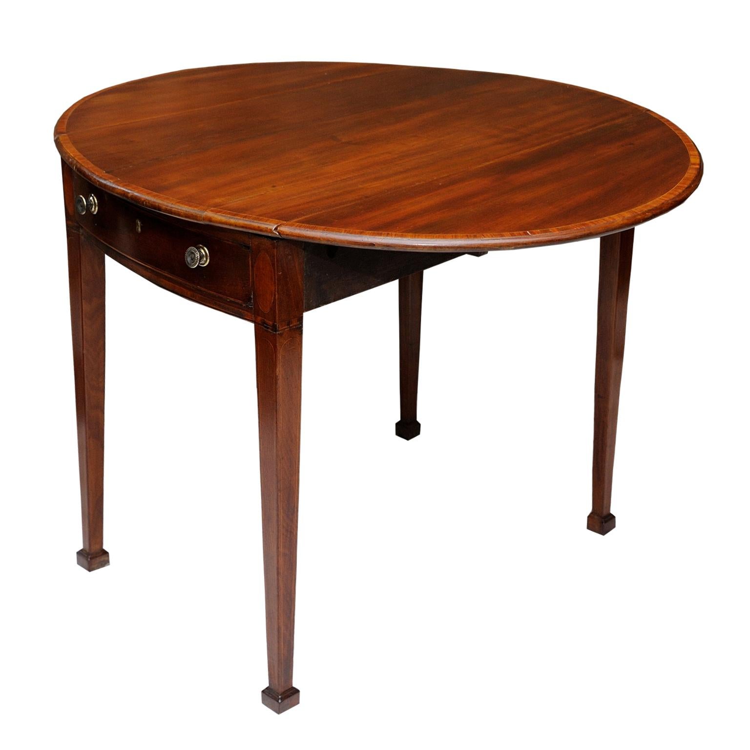 This is a rather lovely English George III Hepplewhite period mahogany oval Pembroke table, with one opening drawer and one faux drawer. Decorated with crossbanding and standing on tapered legs with square toes and retaining original handles, circa