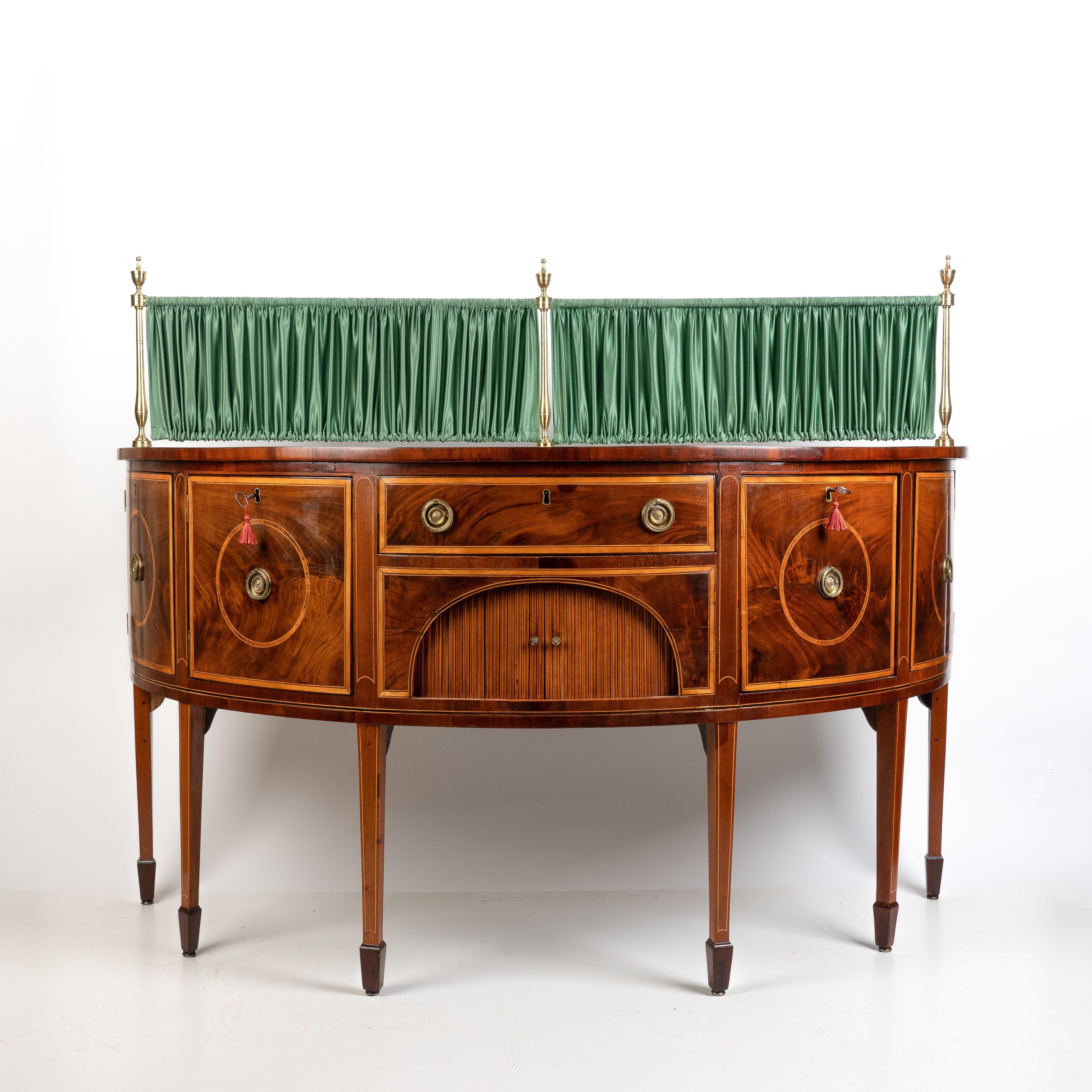 George III demi-lune sideboard with four square keyed drawer/door fronts centered on brass drop ring pulls within a circle of rosewood cross banding. The drawer/door fronts are divided in the center of the bow by a long drawer over a rectangular