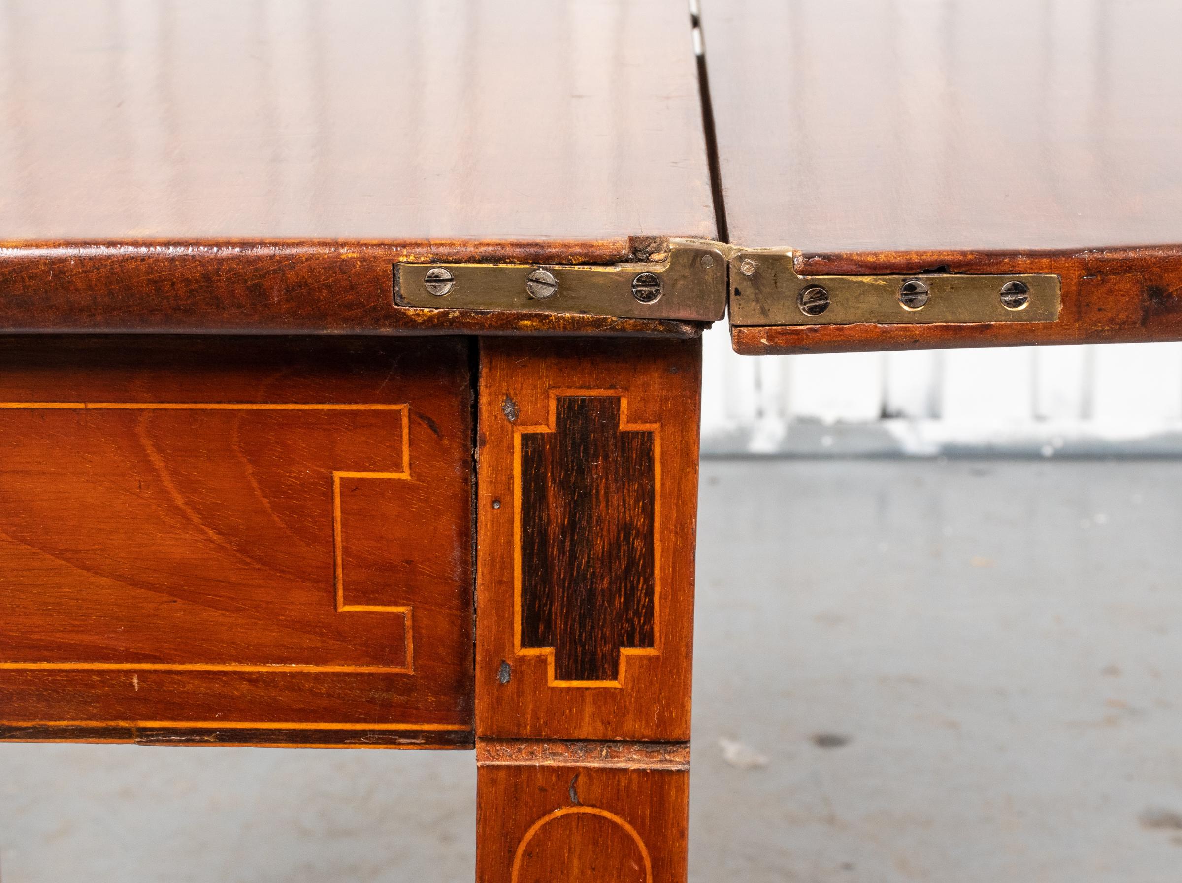 Georges III. Mahagoni-Tisch mit Intarsien, spätes 18. Jh., Klappplatte über der Schürze mit geometrischer Intarsienarbeit, hinten mit Torbeinen. In sehr gutem Vintage-Zustand. 

Händler: S138XX