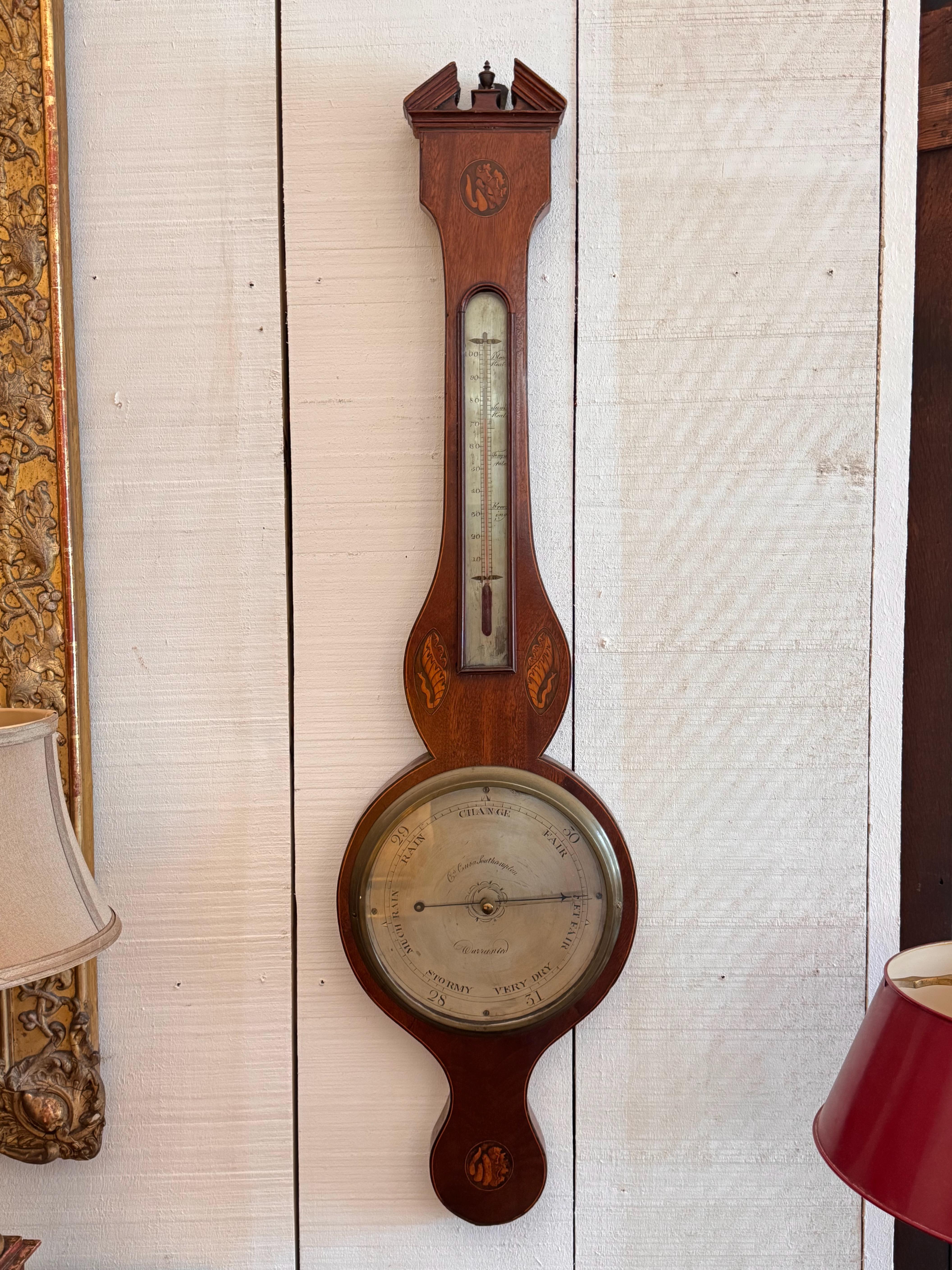 Baromètre et thermomètre d'époque George III, logés dans un coffret en acajou finement façonné avec des motifs en bois de satin et en coquillages incrustés. Le cadran argenté est gravé 