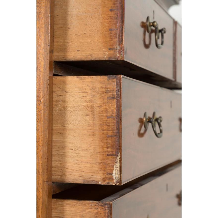 Cassettone in mogano di Giorgio III, con cresta orizzontale e modanatura a dentello che sormonta una cassa a due o sei cassetti, i frontali di ciascun cassetto con bordatura a gallo e tiretti in ottone, il tutto terminante su piedi a staffa.
Altezza