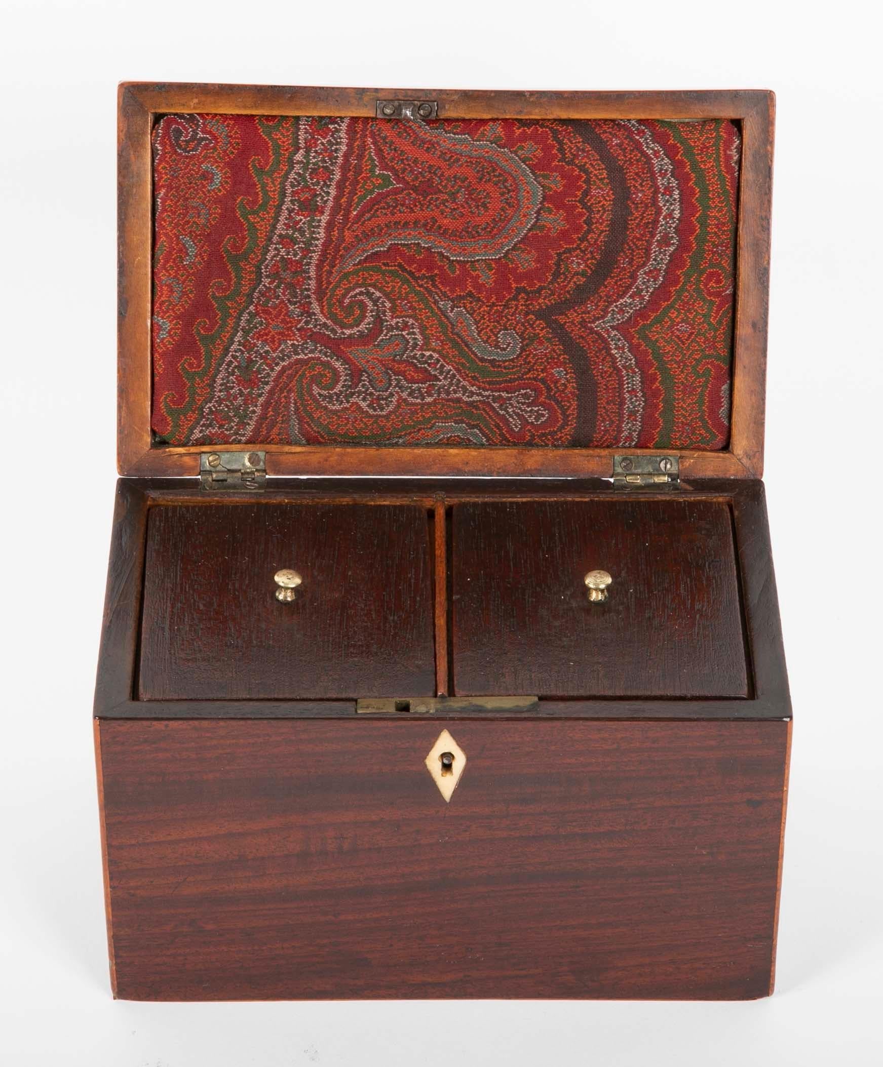 A fine English mahogany tea caddy with fruitwood inlay from the reign of George III. The interior with two lidded compartments for tea leaves, with the personal touch of a piece of a Kashmir shawl tucked into the top as a liner. Inlaid diamond