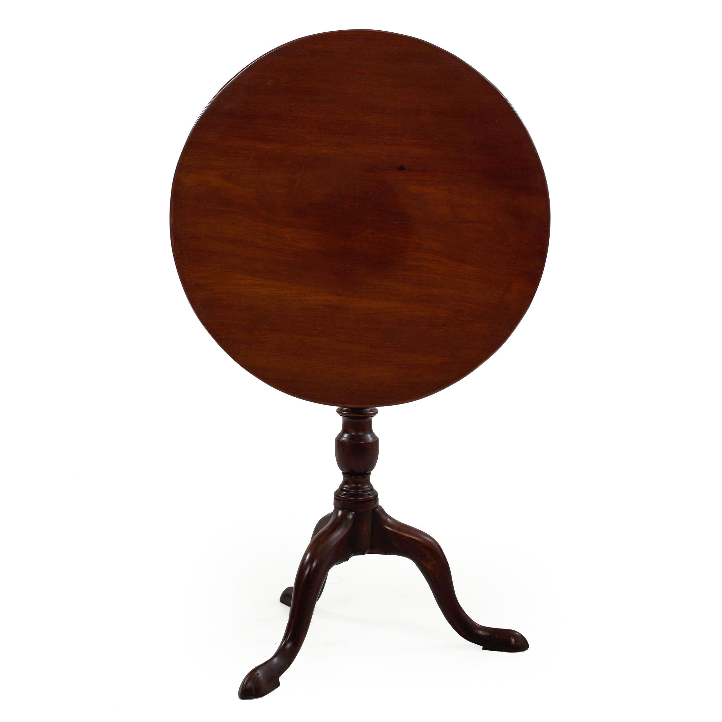 A very nice George III period mahogany tea table with a circular tilt-top over a ring-turned vasiform baluster pedestal raised on cabriole legs terminating in spade feet over integral shoes. It retains a lovely old surface throughout, the patina