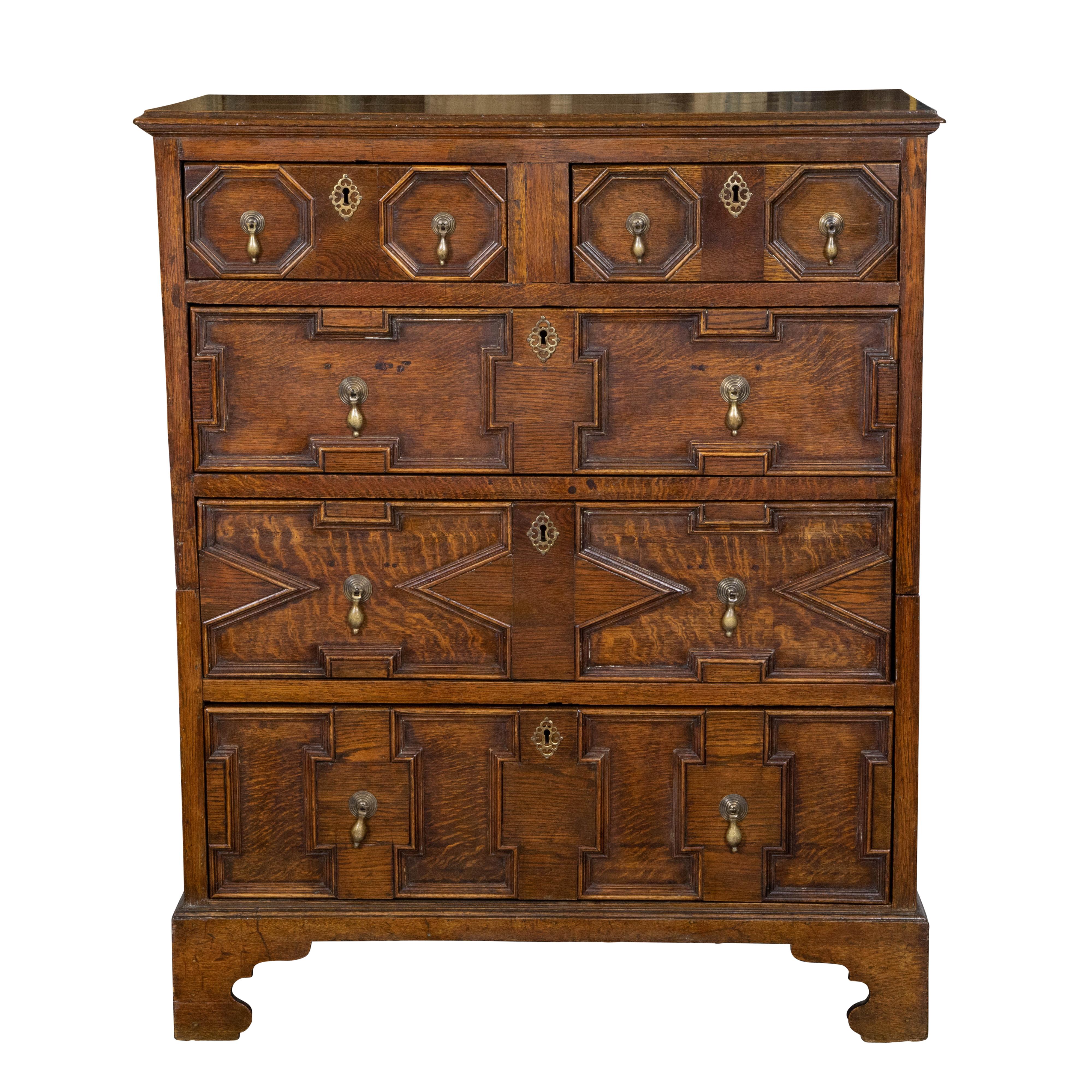 An English George III Period two part oak chest from the early 19th century, with geometric front, five drawers and brass hardware. Created in England during the reign of King George III in the early years of the 19th Century, this oak chest, made
