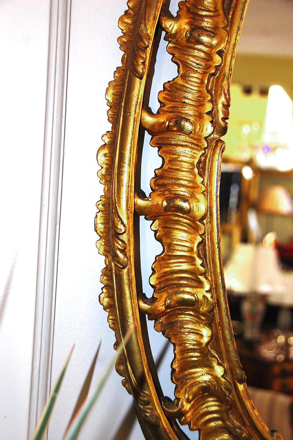 Miroir ovale sculpté à la feuille d'or avec des motifs de vagues et de feuilles, vers 1790, période George III. Cette taille modeste s'adapte bien au-dessus d'une commode, dans un hall d'entrée ou tout autre endroit où une certaine élégance est