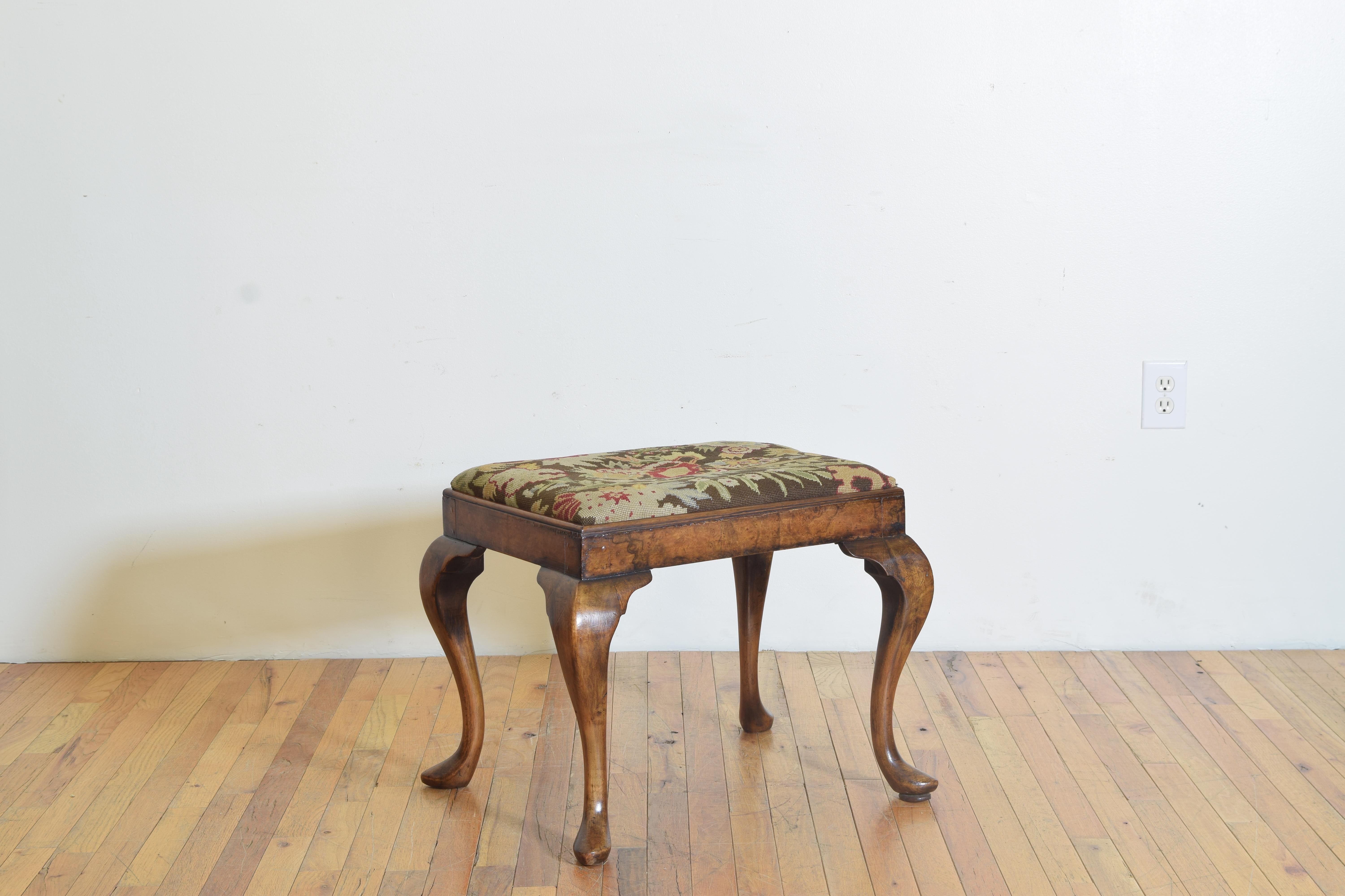 Having a drop in needlepoint upholstered seat, the bench with a molded edged frame and having shaped cabriole legs with a stylized scroll ending in pointed Queen Anne feet