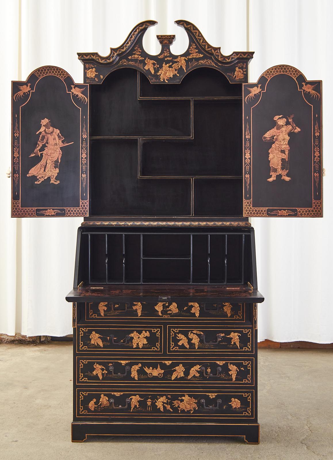 Gorgeous English secretaire bookcase made in the George III taste featuring a black lacquer Japanned case decorated in the chinosierie revival period of the early 20th century Europe. The two-part secretary has a broken pediment cornice on the top