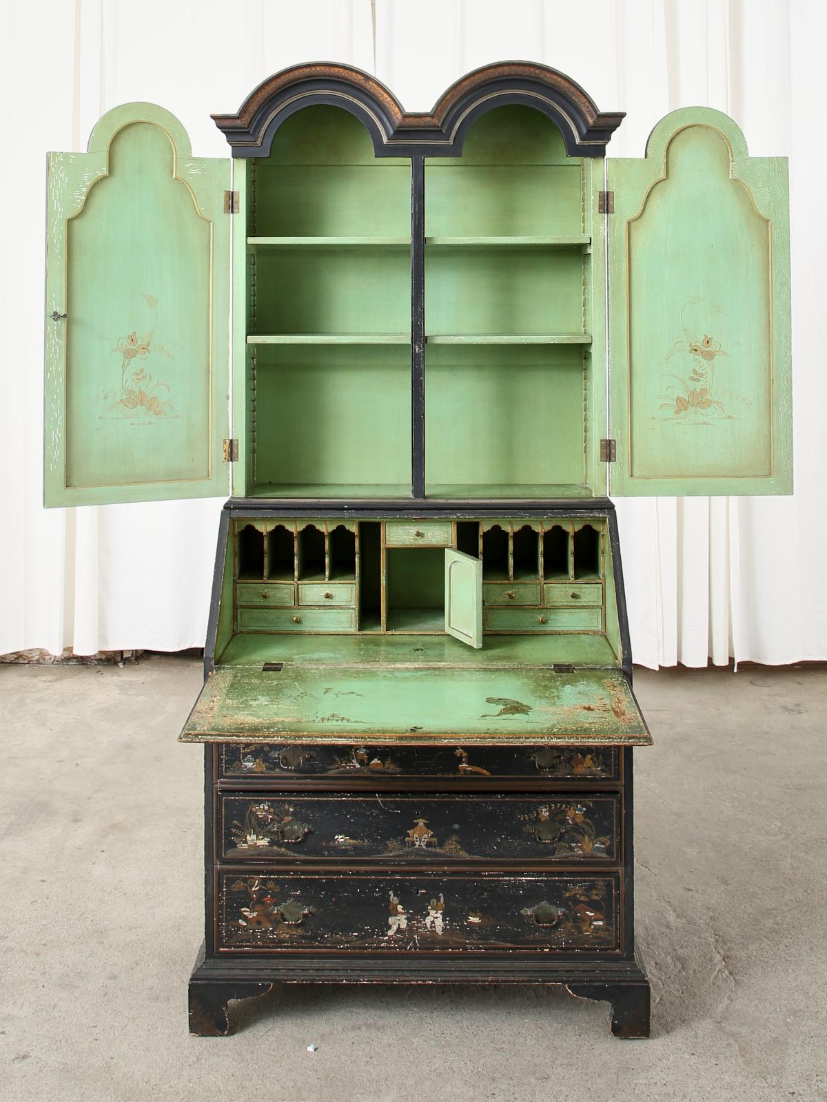 Distinctive Italian chinoiserie lacquered secretary bookcase crafted in the English George III taste. Decorated in the chinoiserie revival period of the early 20th century Europe. The two-piece case features a black lacquer ground embellished with