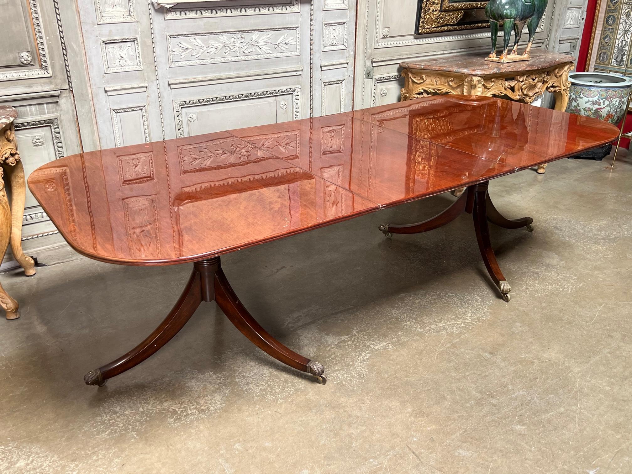 A very nice English George III style double pedestal mahogany dining table with one large leaf. It is constructed in very nice timber and and dates from early to mid 20th century. The width without the leaf is 72.50