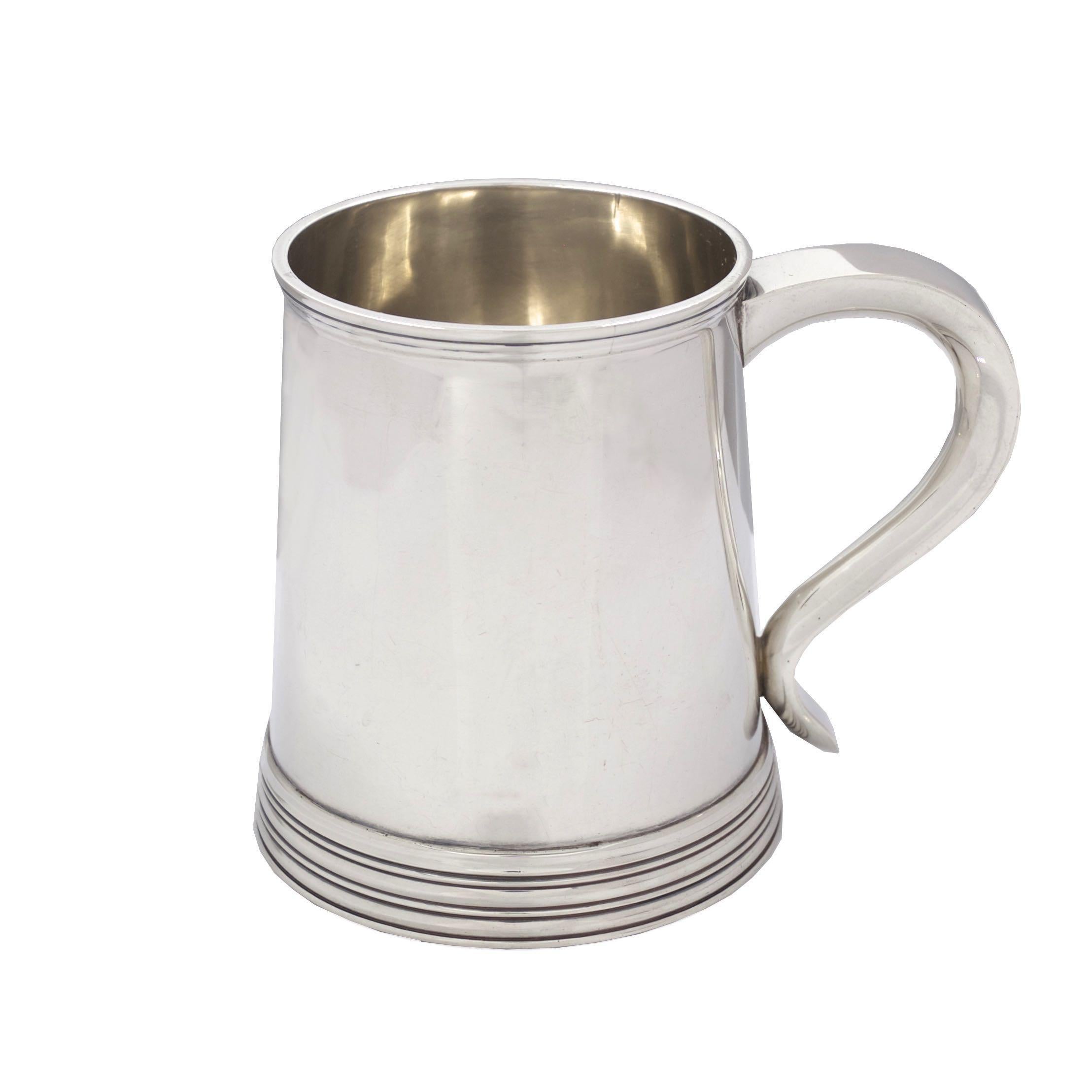 With a fine classical profile, this George III style tankard is a striking functional and decorative object. Free of any monogramming or surface alteration, it is sleek and visually interesting with an austere overall form. The maker's hallmark is