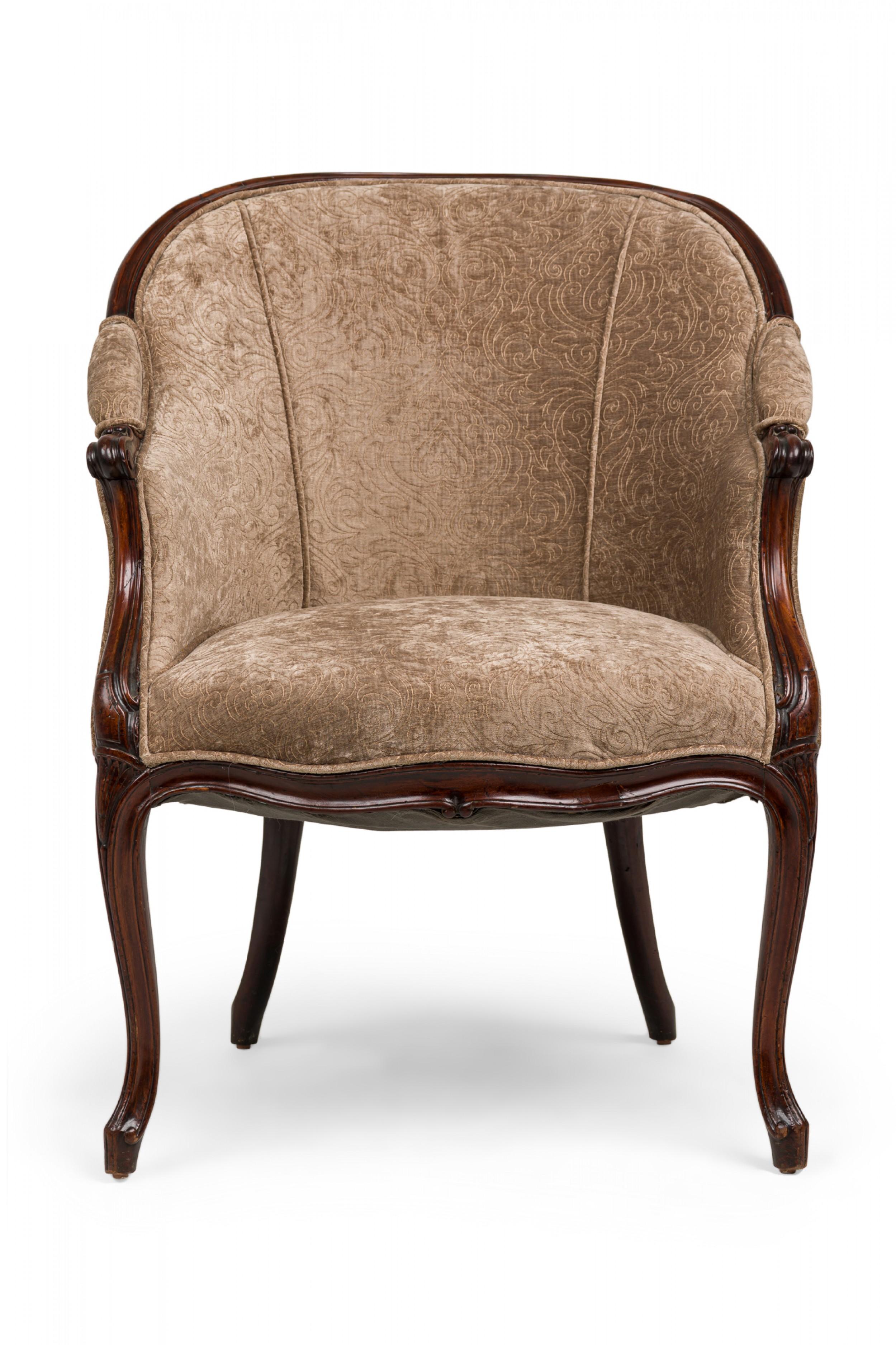 English George III upholstered tub chair with a carved mahogany frame, rounded padded back, sides and seat upholstered in taupe/beige velvet fabric with a subtle embroidered floral pattern, resting on molded tapering, curved legs.
