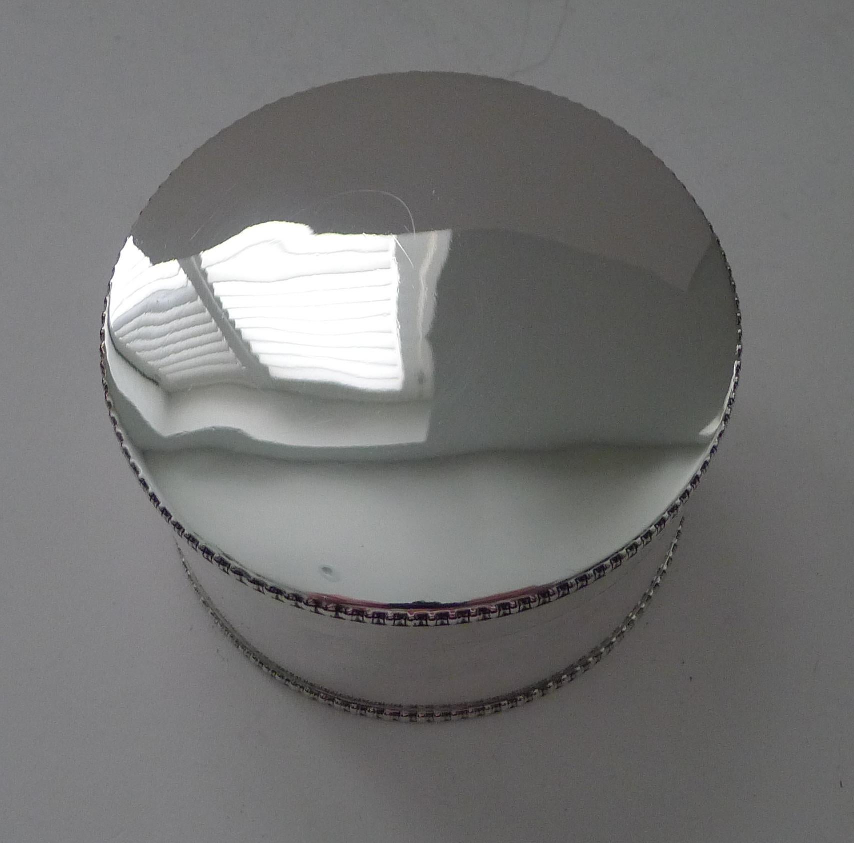 Un elegante e raffinato portabiscotti circolare in argento massiccio con un semplice bordo di perline nella parte superiore e inferiore.

Il coperchio si incastra perfettamente, la cerniera è perfettamente funzionante e la scatola ha il marchio di
