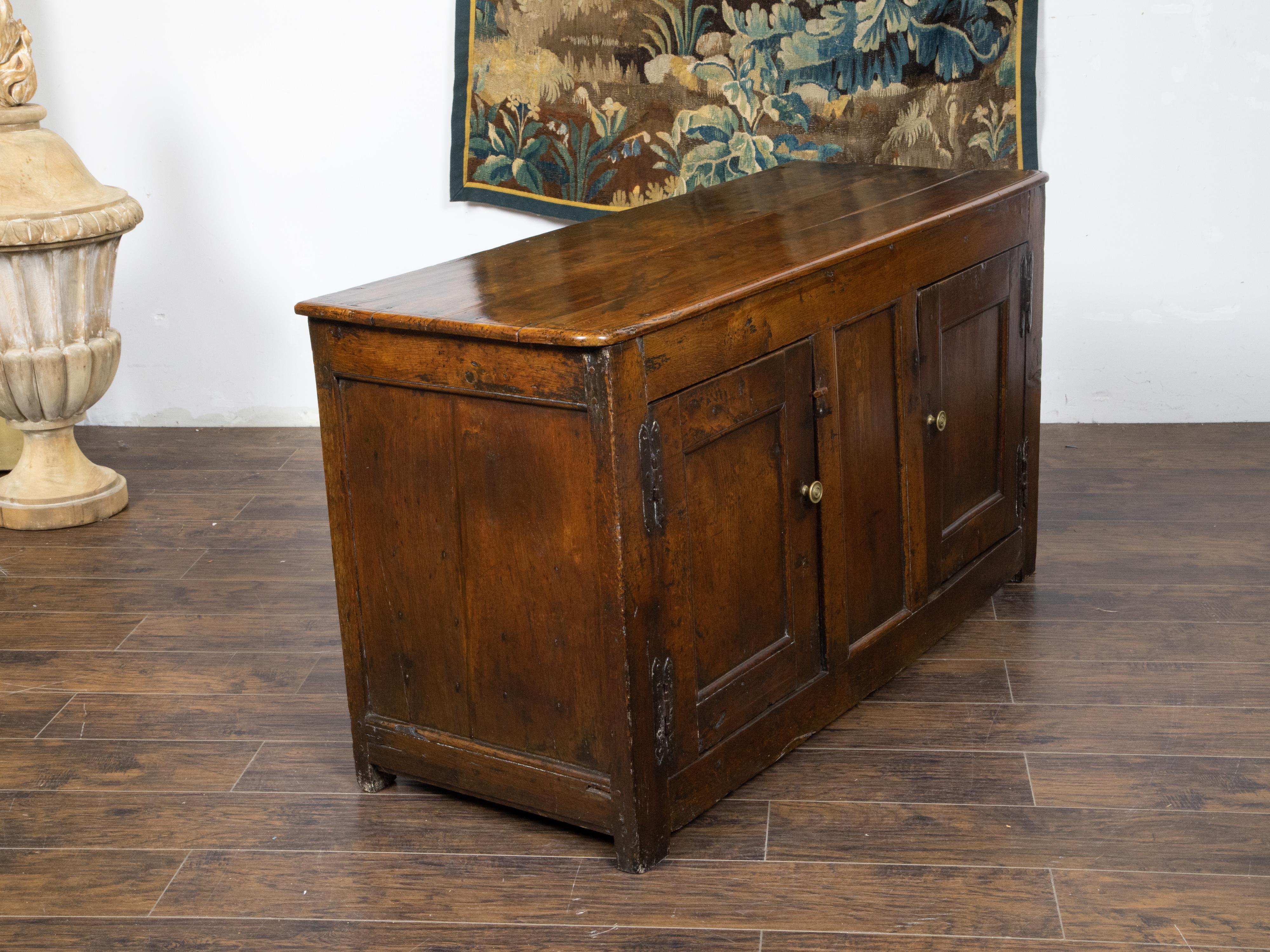 An English Georgian period elm buffet from the 18th century with two doors, recessed panels, iron and brass hardware and nicely weathered patina. Created in England during the early Georgian period in the 18h century, this elm buffet features a
