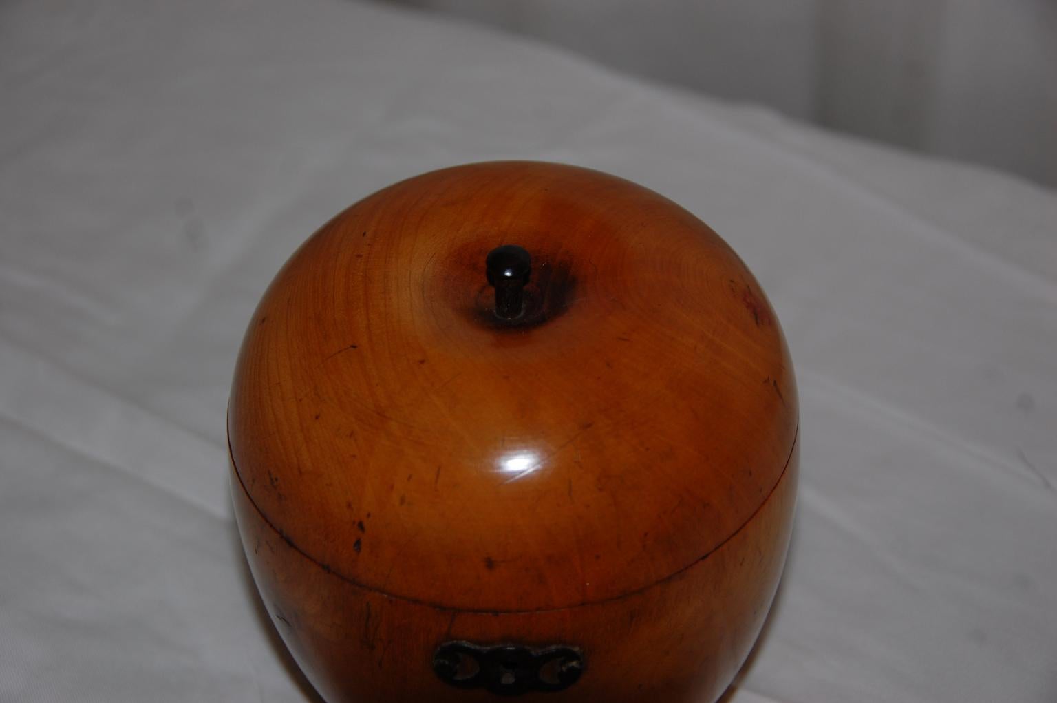 English Georgian apple shaped teacaddy turned from apple wood. This type of tea caddy, most often in the shape of an apple or a pear, is thought to have been made by a wood turner for the owner of a favorite apple tree as a remembrance of the tree.