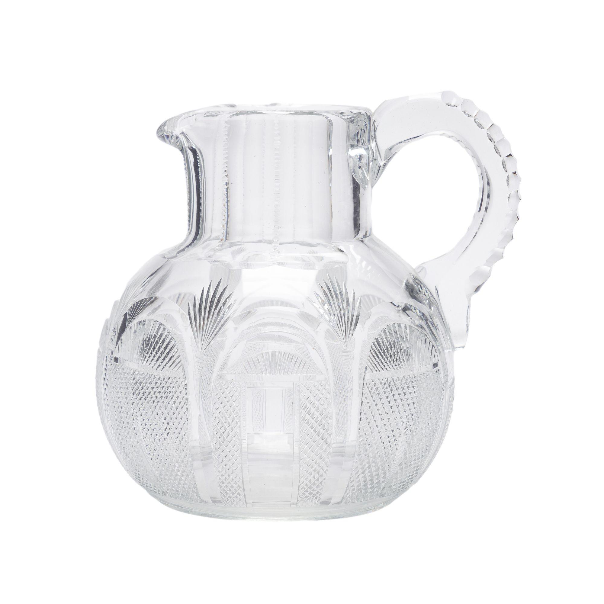 English Georgian blown & cut glass water/whiskey jug. The jug has a panel cut standing rim with spout & attachment of the upper loop handle joining the standing rim to the globe form body. The body of the jug is encircled with seven arched cut