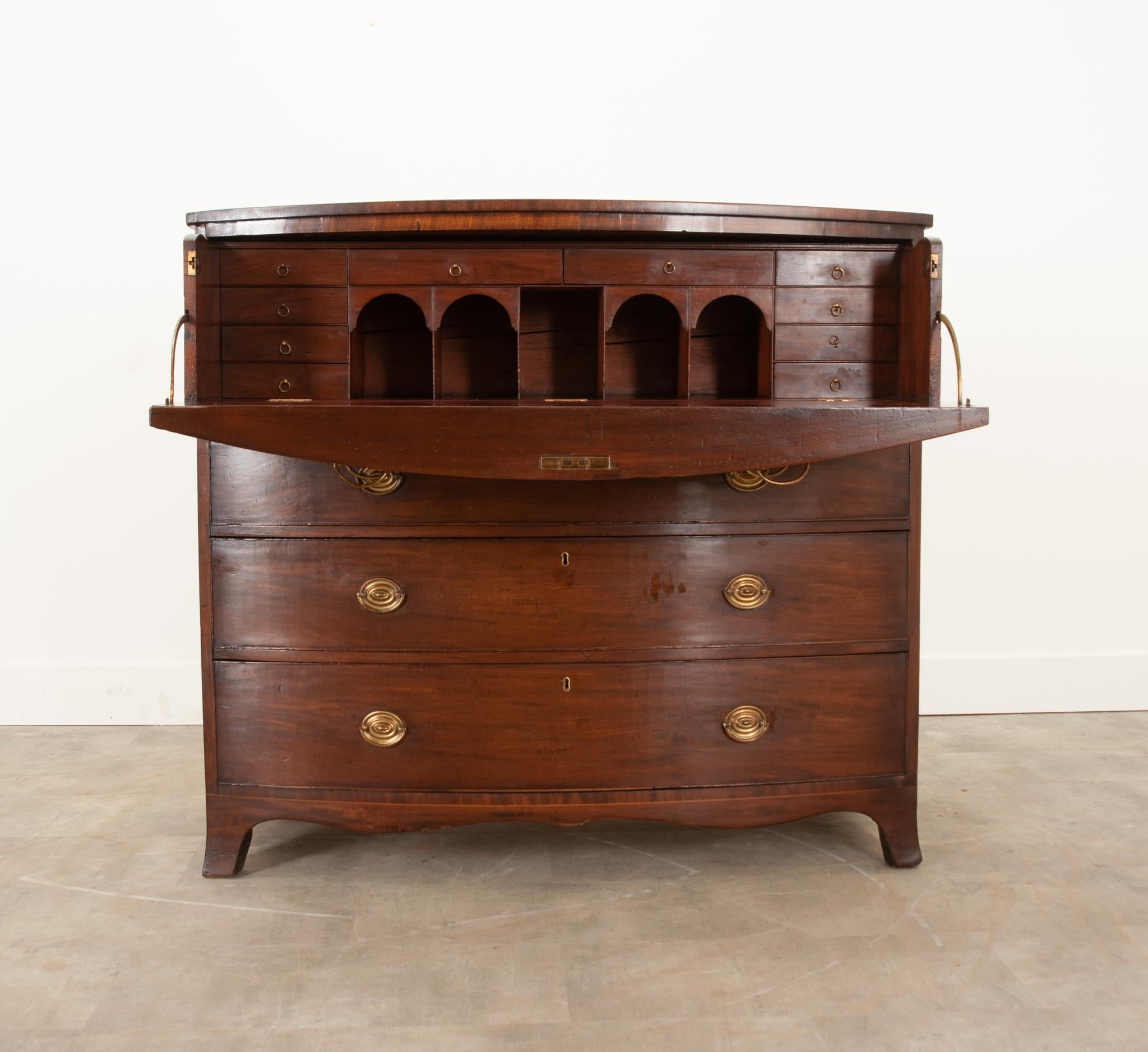 An impressive English Georgian mahogany chest that stands out from the rest. Well taken care of over its lifetime and ready for its next generation of owners. The top two drawers disguise as the drop down desk which conceals 10 drawers and 5 open