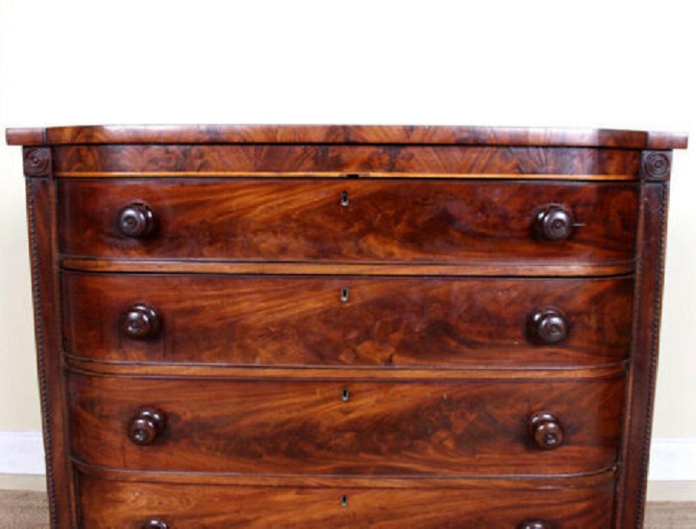 A fine quality George IV period bowfront chest of drawers.
The Cuban mahogany boasting a well figured flamed grain.
Fitted four long graduated drawers flanked by roundel capped upright columns with dovetailed jointing, solid interiors and mounted