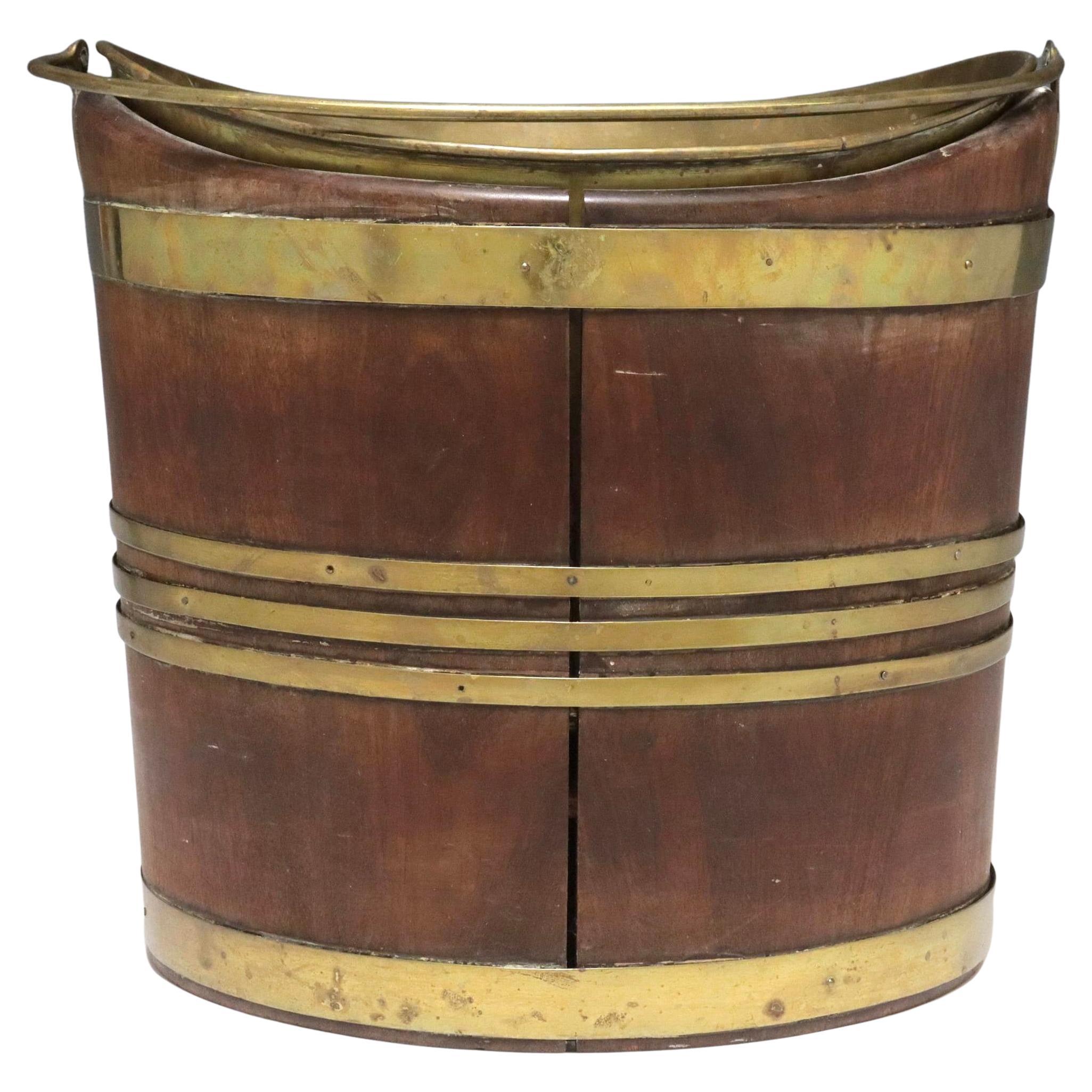 Early 19th century Georgian Brass-Bound Mahogany Peat Bucket With Liner.  These buckets were used for storing and transporting peat, a fuel source. Bucket features a navette form, mahogany staves, and is bound with brass bands. Has a brass top